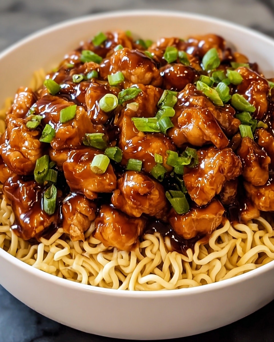 The image shows a white bowl filled with a base layer of light tan cooked noodles that have a slight sheen. On top, there is a thick layer of golden brown pieces of chicken coated in a shiny, dark caramel-colored sauce. Scattered over the chicken are small pieces of bright green chopped scallions, adding a pop of fresh color. The bowl and food sit on a white marbled surface. The photo taken with an iphone --ar 4:5 --v 7