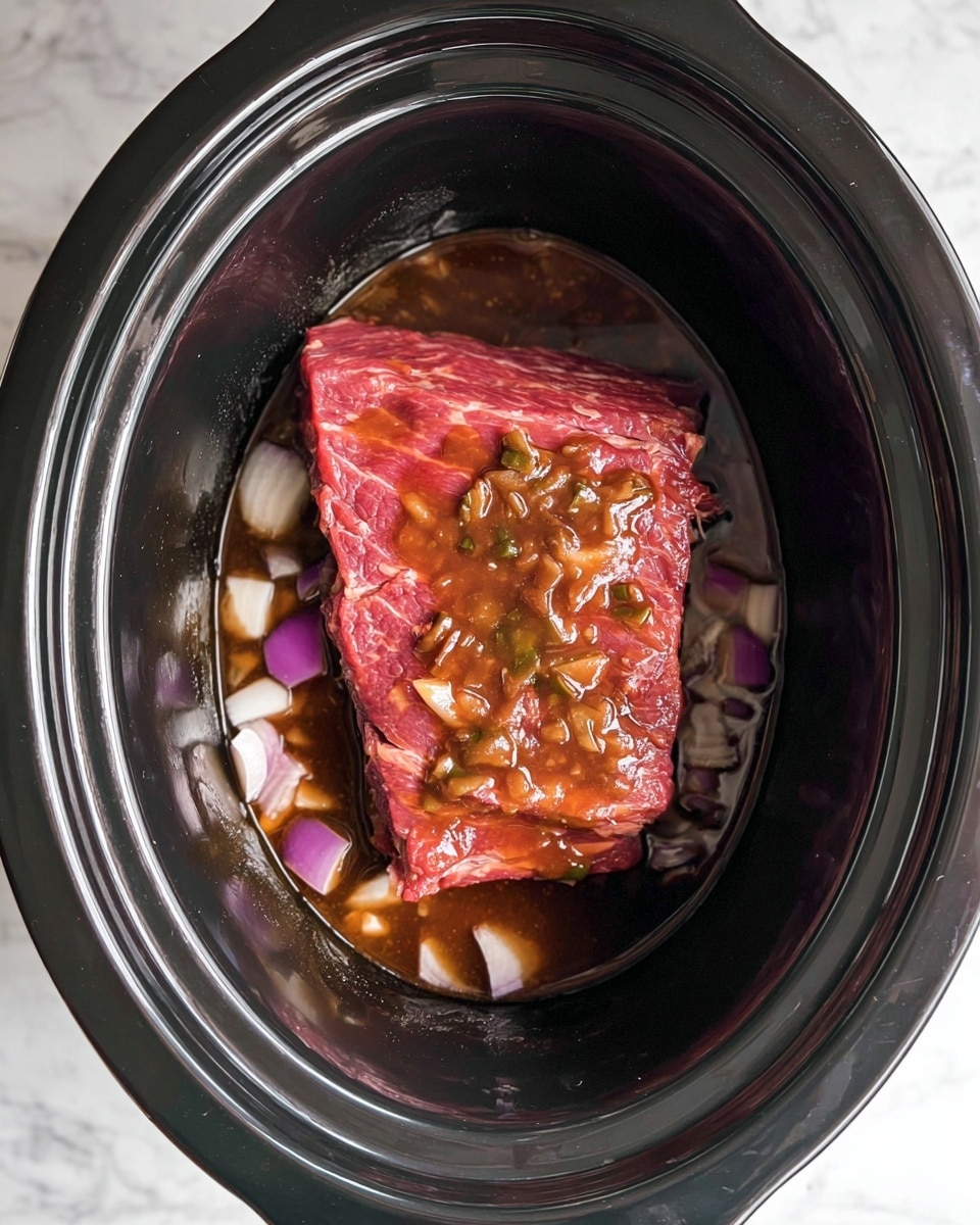 This image shows a thick piece of raw red meat placed in the center of a black slow cooker. The meat is topped with a shiny, chunky brown sauce that has small bits of cooked onions. Underneath the meat are pieces of white and purple chopped onions sitting in a dark brown liquid at the bottom of the cooker. The inner surface of the slow cooker is smooth and black, and the whole scene is set on a white marbled surface. photo taken with an iphone --ar 4:5 --v 7