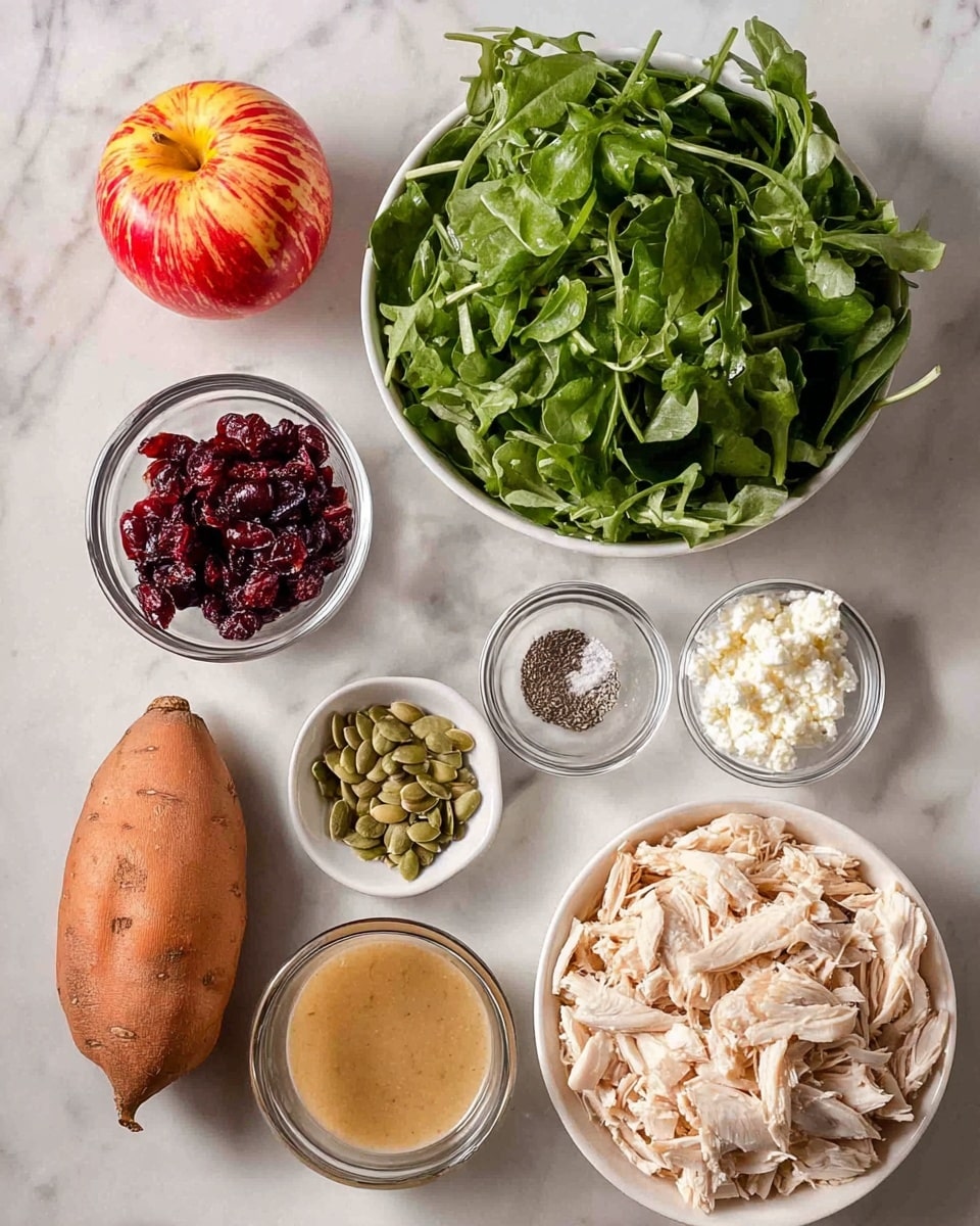 The image shows separate ingredients arranged on a white marbled surface. At the top right, a white bowl filled with shredded, light beige chicken sits next to a white bowl full of fresh, dark green arugula leaves. Above the arugula, there are three small clear bowls: one with white crumbled cheese, one with dark red dried cranberries, and a small one containing salt and pepper. Below these, a small clear bowl holds light green pumpkin seeds, and beside it is a small glass container with a creamy, light brown dressing. To the left, a red apple with yellow streaks leans next to a small, light brown sweet potato. The photo taken with an iphone --ar 4:5 --v 7