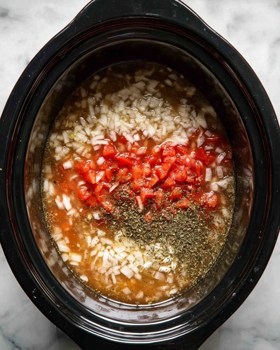 Inside a black slow cooker, there is a mix of four visible layers: at the bottom, a light brown broth fills most of the pot, above it sits a layer of small, bright red tomato pieces scattered in the center, then a layer of finely chopped white onions spread evenly across the surface, and finally, a sprinkled layer of dark green dried herbs rests mostly around the edges, floating lightly on top. The pot is placed on a white marbled surface. Photo taken with an iphone --ar 4:5 --v 7