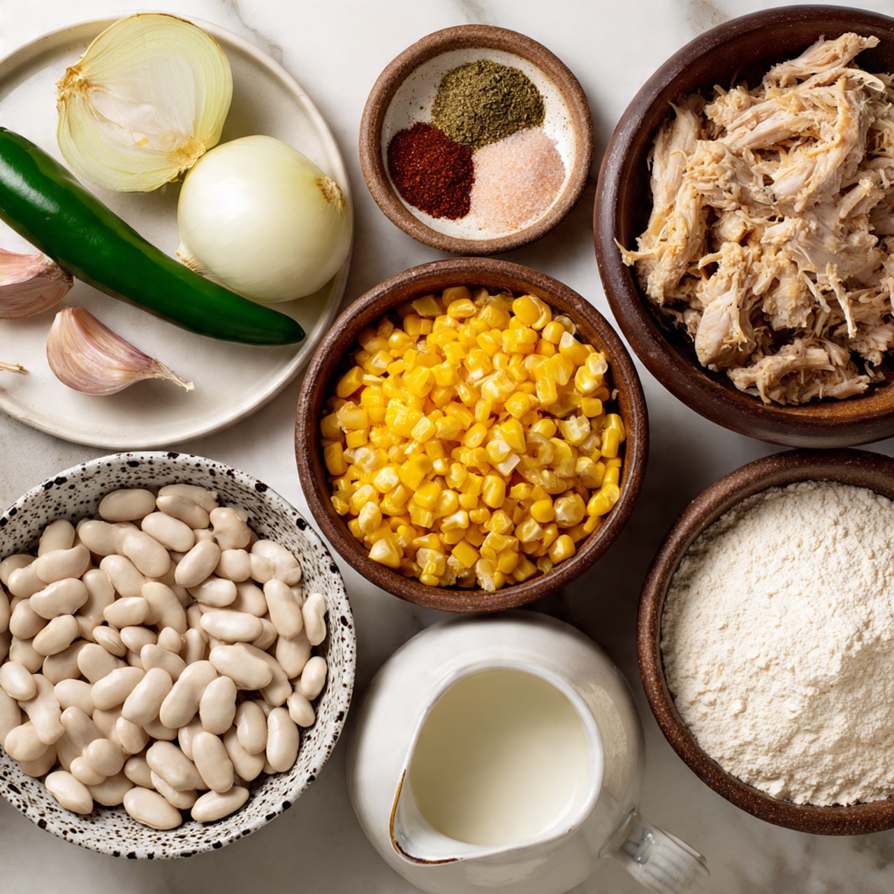 The image shows several bowls and a white plate with raw ingredients on a white marbled surface. In the middle is a brown bowl filled with shredded light brown cooked chicken. Below it, a white bowl with black spots holds bright yellow corn kernels. To the left, a brown bowl contains large, smooth white beans. On the top left, a white plate holds a whole green jalapeno, three cloves of garlic, and a white onion cut into quarters. Above the chicken, a speckled bowl contains four small piles of spices: greenish dried herbs, pale pink salt, reddish brown spice, and a light brown spice. To the right, a small bowl with diced cooked pickled vegetables sits next to another brown bowl filled with white flour. In the bottom right corner, a white jug holds white milk. All items are neatly arranged and well-lit. photo taken with an iphone --ar 4:5 --v 7