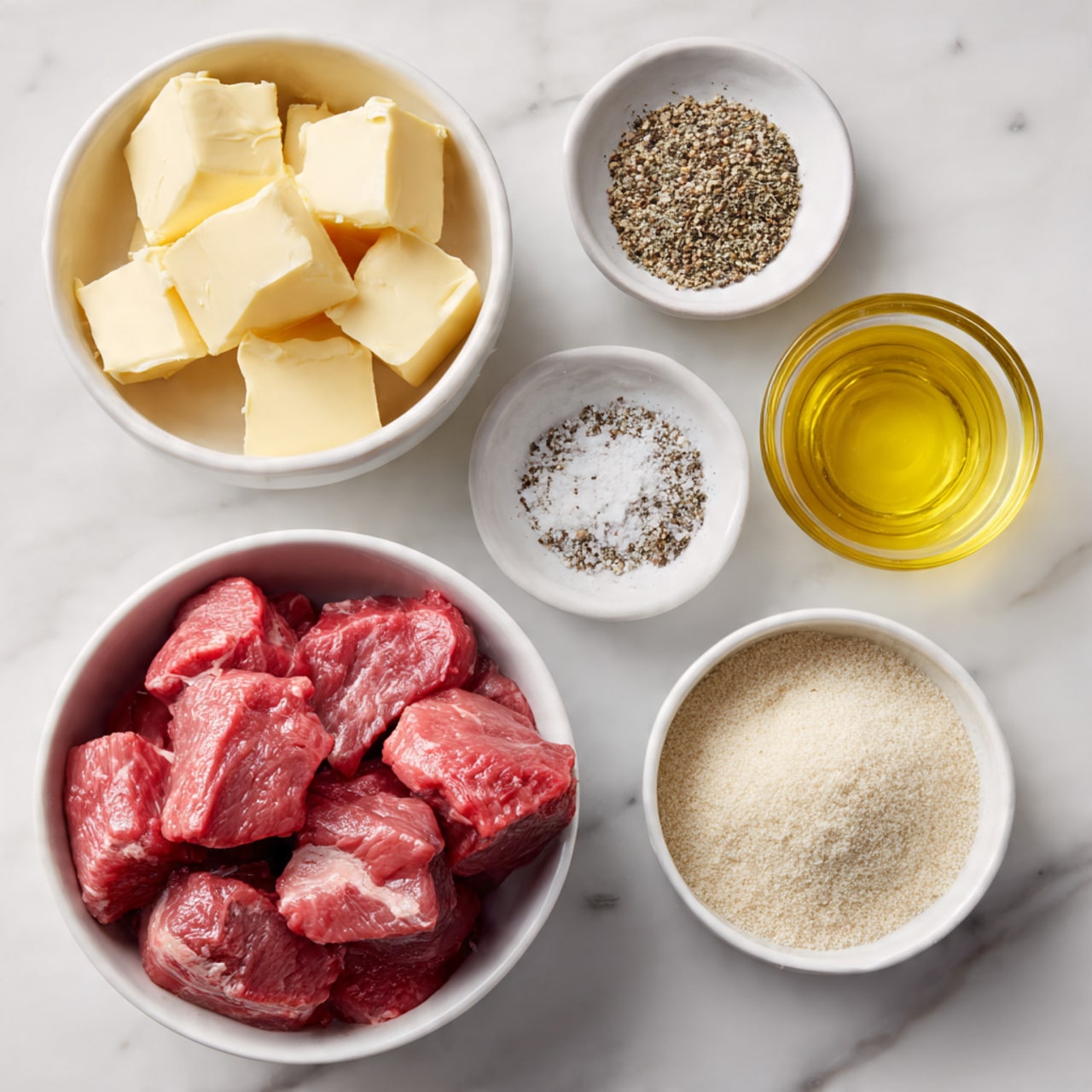 The image shows four white bowls on a white marbled surface. The largest bowl at the bottom is filled with red raw beef chunks that are thick and uneven in size. To the top left is a smaller bowl with several thick, pale yellow butter slices stacked together. At the top right, there is a small bowl filled with golden yellow melted butter or oil. To the right middle, a small bowl contains four separate piles of spices: light beige garlic powder, white salt, black pepper, and a darker beige seasoning, all arranged in neat sections. The bowls are plain and simple with a slightly rounded shape photo taken with an iphone --ar 4:5 --v 7