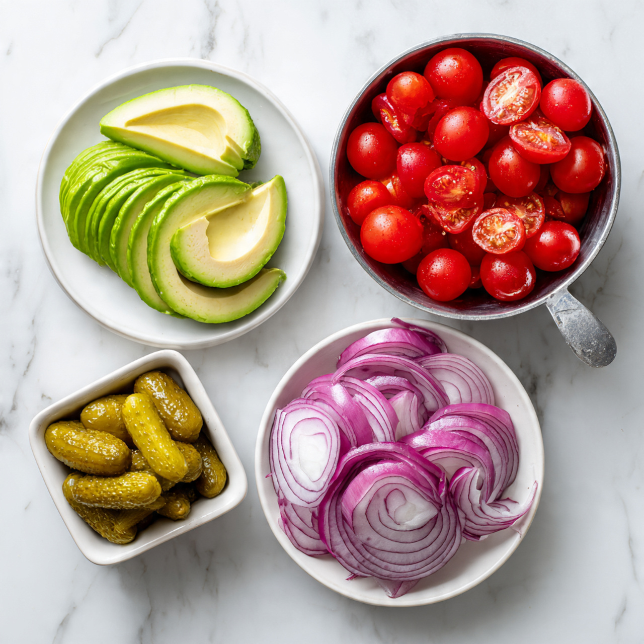 The image shows four small containers holding fresh ingredients on a white marbled surface. At the top left, a white round plate holds two halves of bright green avocado, sliced thinly. To the top right, a metal measuring cup is filled with shiny, red cherry tomatoes, some cut in half showing their juicy interior. At the bottom right, a white round plate contains thin, curved slices of purple and white red onion. At the bottom left, a small square white bowl holds several sliced pickles, showing their yellowish-green color and textured surface. The arrangement is neat and colorful, showing fresh ingredients clearly. photo taken with an iphone --ar 4:5 --v 7