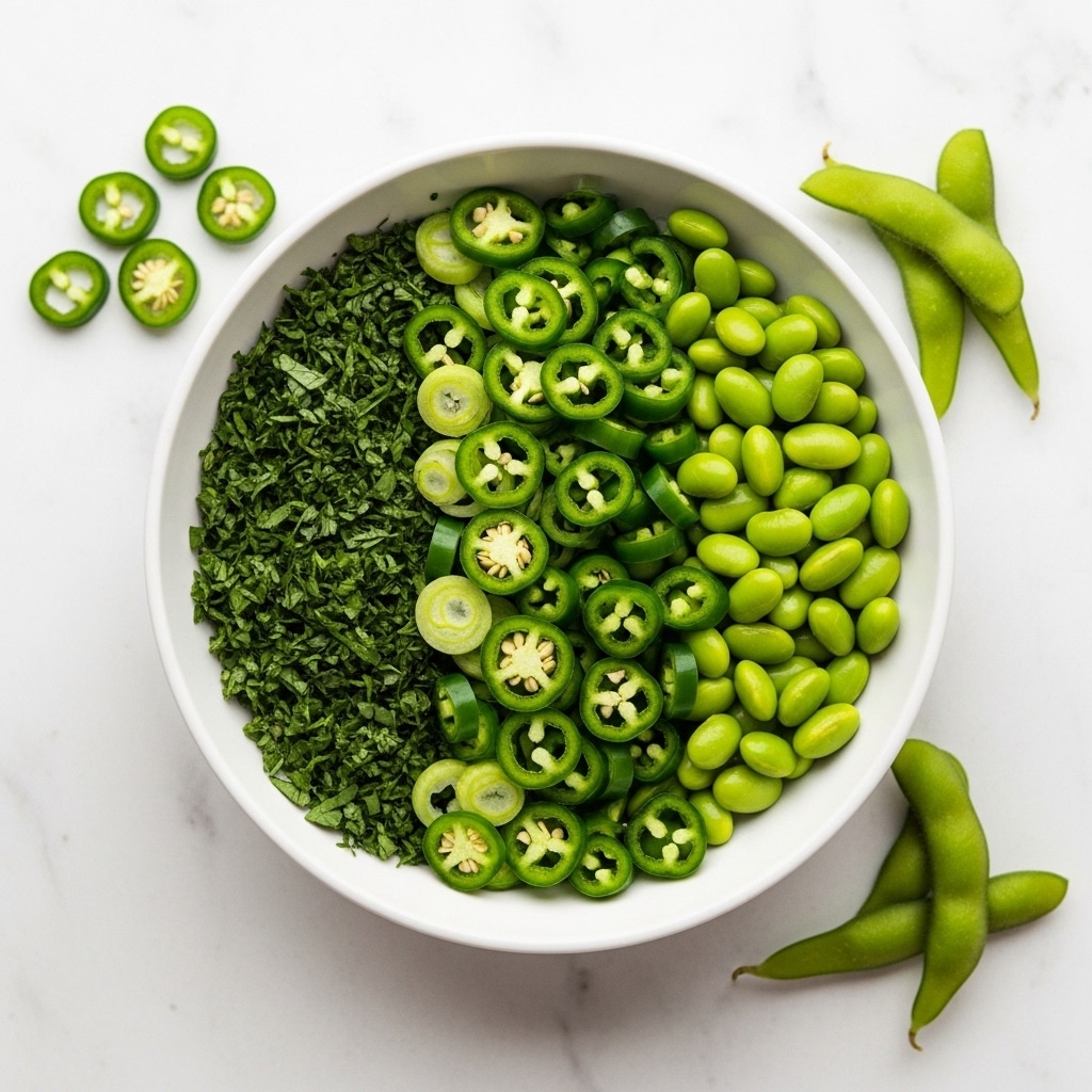 A white bowl sits on a white marbled surface, filled with three green layers arranged side by side. On the left is a pile of finely chopped dark green herbs, in the middle are thinly sliced bright green chili or green onion rings, and on the right are plump, light green edamame beans. The colors are fresh and vibrant, emphasizing different green tones and textures. A few pieces of the sliced green vegetables are scattered around the bowl. Photo taken with an iphone --ar 4:5 --v 7