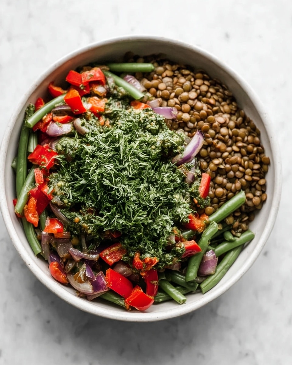 A white bowl on a white marbled surface holds a colorful dish with three main parts. On the right side, small round brown lentils fill about one-third of the bowl with a firm texture. The left side has cooked green beans mixed with red bell pepper chunks and purple onion pieces, all slightly shiny and soft-looking. On top of the green beans, a generous layer of finely chopped fresh green herbs covers the middle part, adding a vibrant green color and a delicate texture. Photo taken with an iphone --ar 4:5 --v 7