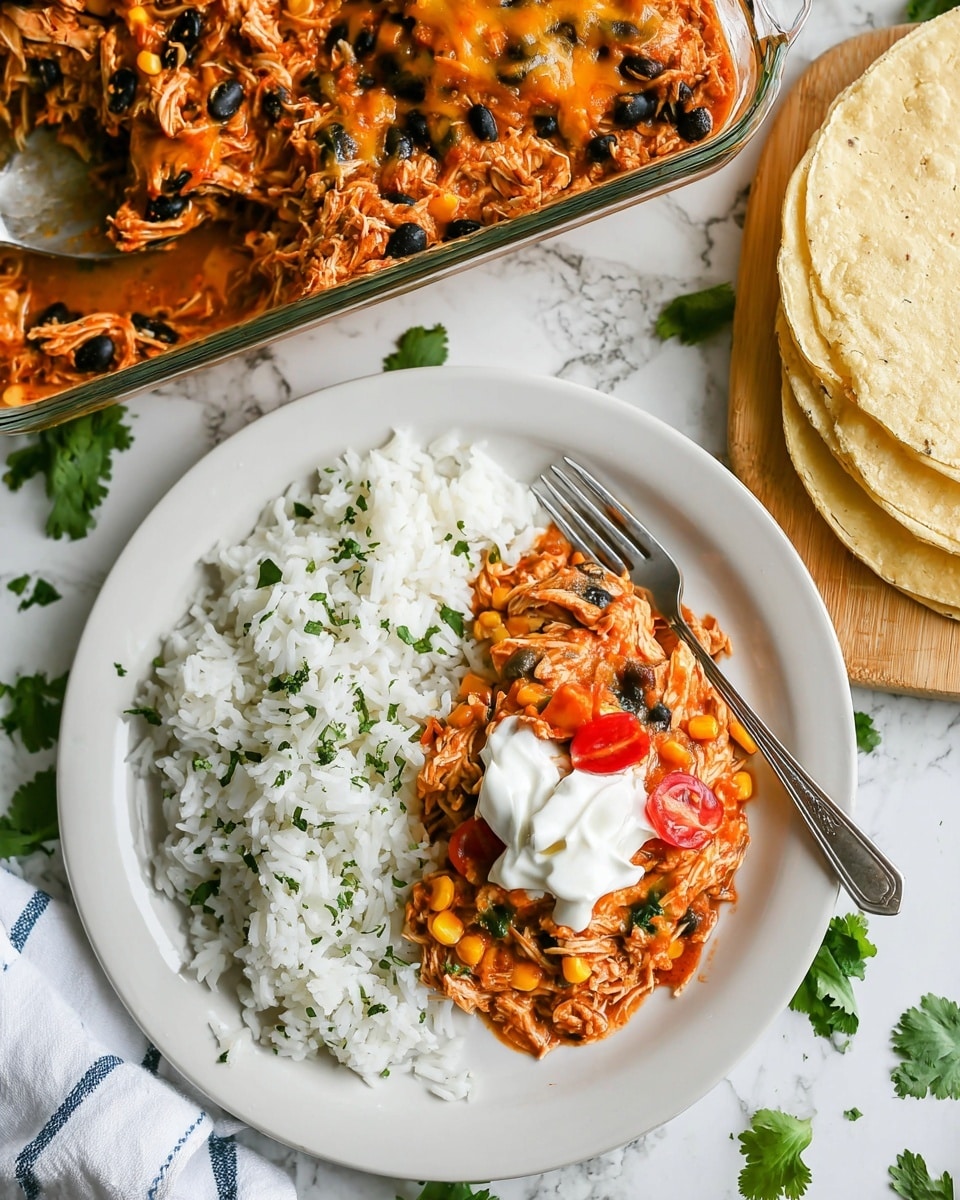 A large spoonful of layered casserole is lifted above a white marbled surface, showing three main layers: the bottom layer is made of light beige tortilla pieces, the middle layer consists of shredded light brown chicken mixed with black beans and yellow corn, and the top layer is bright orange melted cheese sprinkled with small green herb pieces. The casserole in the white dish below has a similar layering and is garnished with chopped green herbs. The background is blurred with shiny forks and a faint green plant visible. photo taken with an iphone --ar 4:5 --v 7