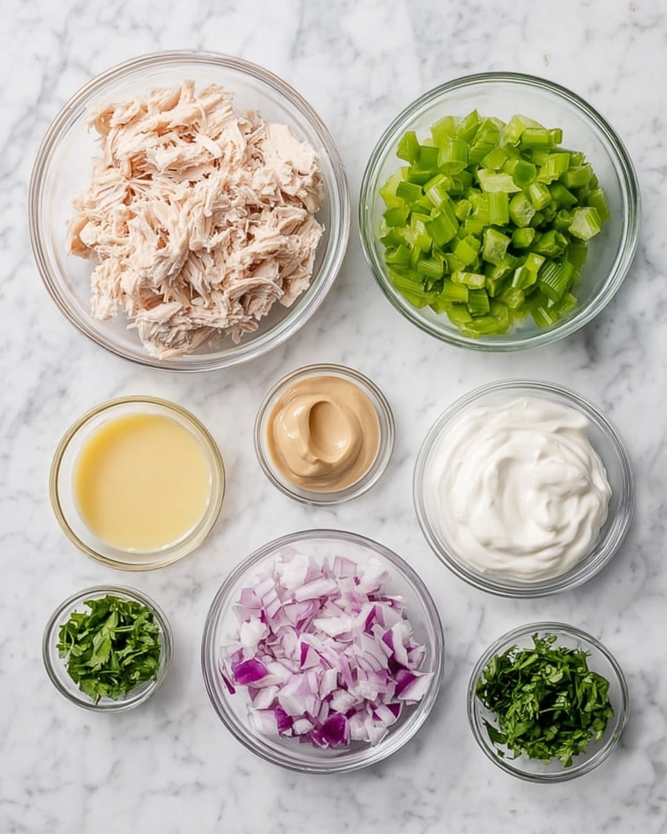 Seven small clear glass bowls are arranged on a white marbled surface. The largest bowl on the left holds shredded light pink cooked chicken. To its right, a bowl is filled with finely chopped bright green celery. Next to it on the right is a bowl with smooth white sour cream. Below these, from left to right, there is a small bowl with creamy light brown mustard, a small bowl of pale yellow lemon juice, a small bowl with finely chopped red onion in purplish white pieces, and a small bowl with chopped dark green cilantro. Photo taken with an iphone --ar 4:5 --v 7
