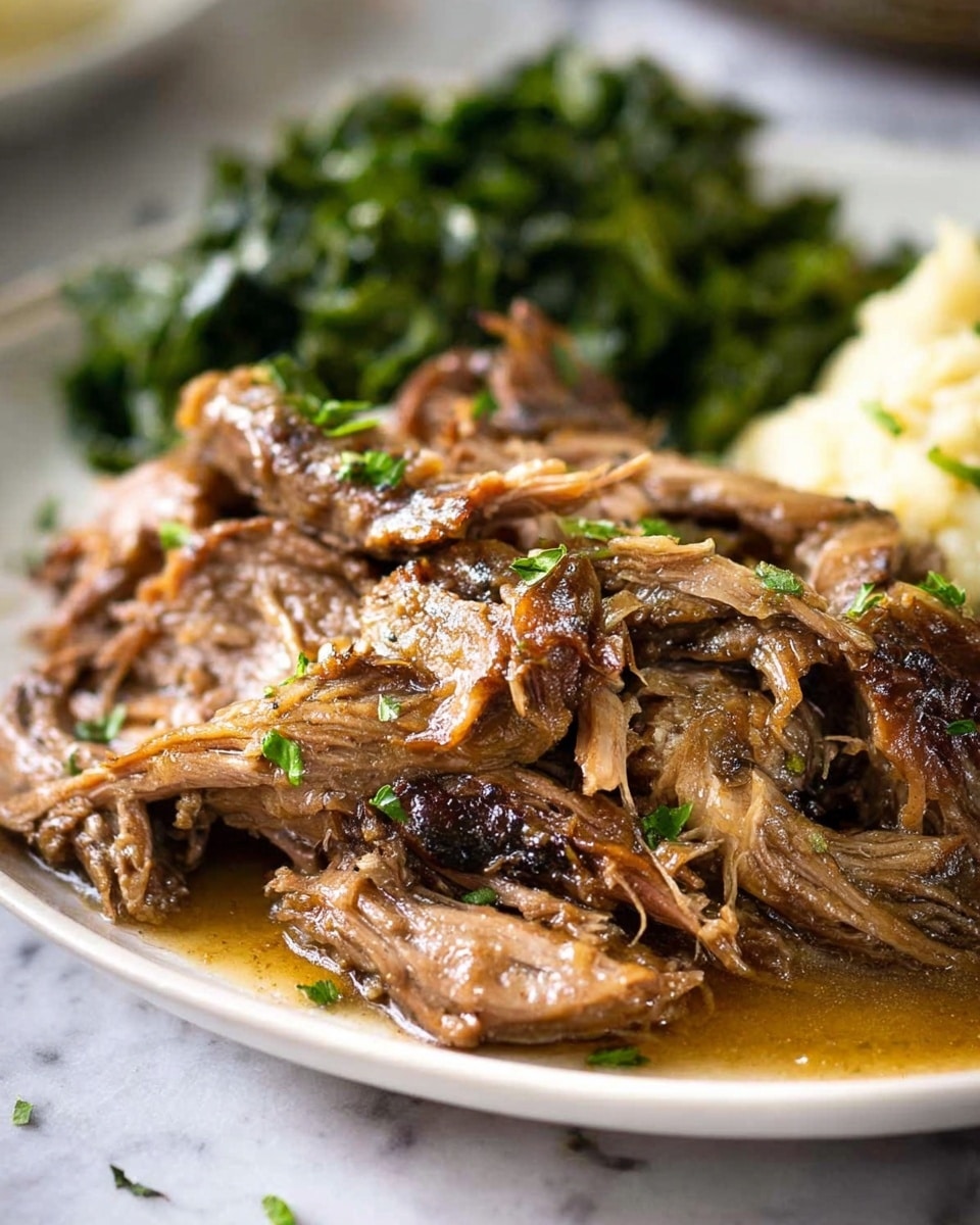 The image shows a close-up of shredded, tender meat with a light brown color and juicy texture, covered in a shiny, smooth brown sauce. The meat pieces are layered unevenly at the front of a white plate, with small green herb bits sprinkled on top. In the background, there is a pile of dark green cooked leafy vegetables and a light tan creamy side, all sitting on a white marbled surface. The photo captures the food with warm, natural lighting, highlighting the texture and moisture of the meat. Photo taken with an iphone --ar 4:5 --v 7