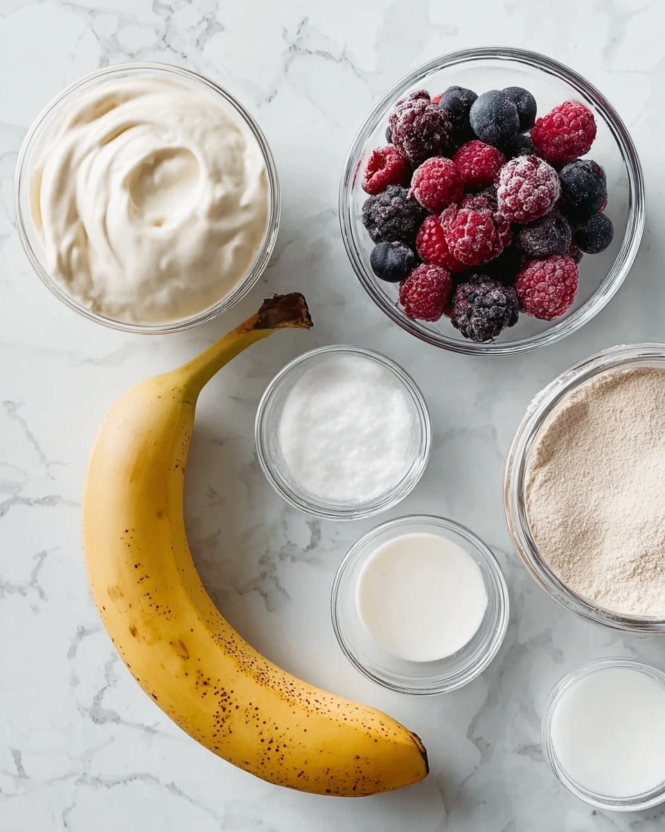 The image shows a close-up of several ingredients arranged on a white marbled surface. At the center, there is a whole yellow banana with some brown spots. Surrounding it are five small clear glass bowls: one with mixed frozen berries in shades of red, blue, and purple; one with a white creamy substance that looks smooth and thick; one with white powder; one with white milk; and part of a container with light brown powder or powder-like substance. The colors are mostly white and natural tones from the banana and berries. photo taken with an iphone --ar 4:5 --v 7