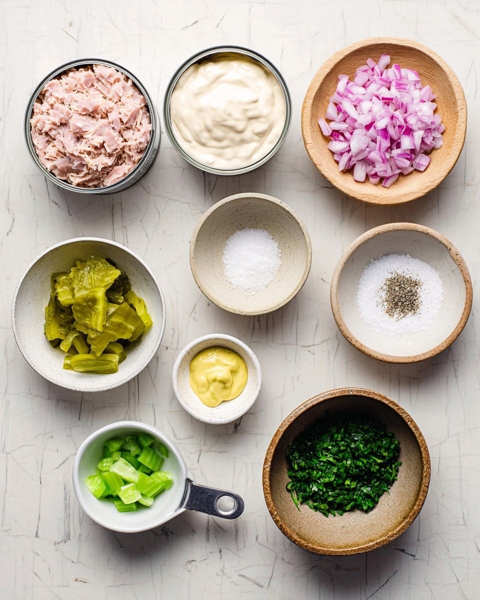 The image shows various ingredients arranged neatly on a white marbled surface. There are two open cans of light pink tuna fish, one on the top left and the other below it. Next to the top can is a small white bowl filled with creamy white mayonnaise. Above it, a wooden bowl holds finely chopped red onions with a light purple hue. To the right, another wooden bowl contains white coarse salt with black pepper sprinkled on top. Below the salt is a tiny white dish with yellow mustard. Near the bottom center, a small speckled white bowl holds chopped bright green pickles. Below that, a silver measuring cup contains small pieces of fresh light green celery. On the right side, a rustic brown dish contains chopped dark green herbs. The layout is clean and organized, all set on the white marbled surface. Photo taken with an iphone --ar 4:5 --v 7