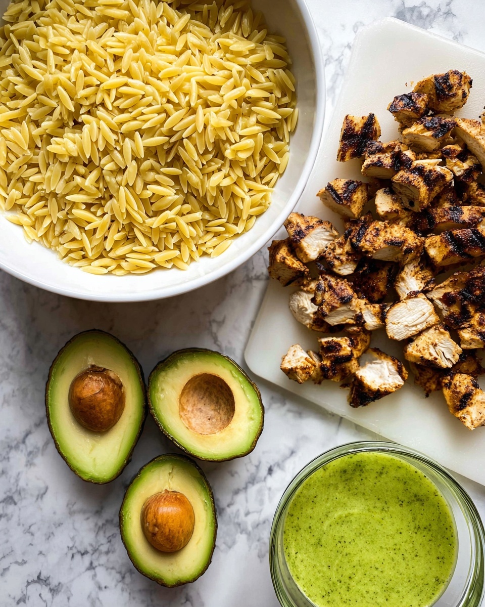 The image shows a white bowl filled with small yellow orzo pasta on the left side. To the right, there is a white cutting board with pieces of grilled chicken that are golden brown with some dark charred spots. Below the cutting board, four halved avocados are placed on a white marbled surface, displaying their smooth green flesh and brown seeds inside two of the halves. In the bottom right corner, there is a clear glass container holding a bright green sauce. The overall background is a white marbled texture. photo taken with an iphone --ar 4:5 --v 7