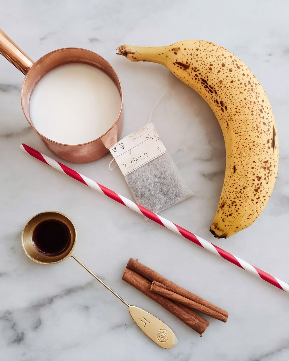 The image shows a white marbled surface with several ingredients arranged on it. On the left, there is a small copper measuring cup filled with milk, next to a tea bag labeled