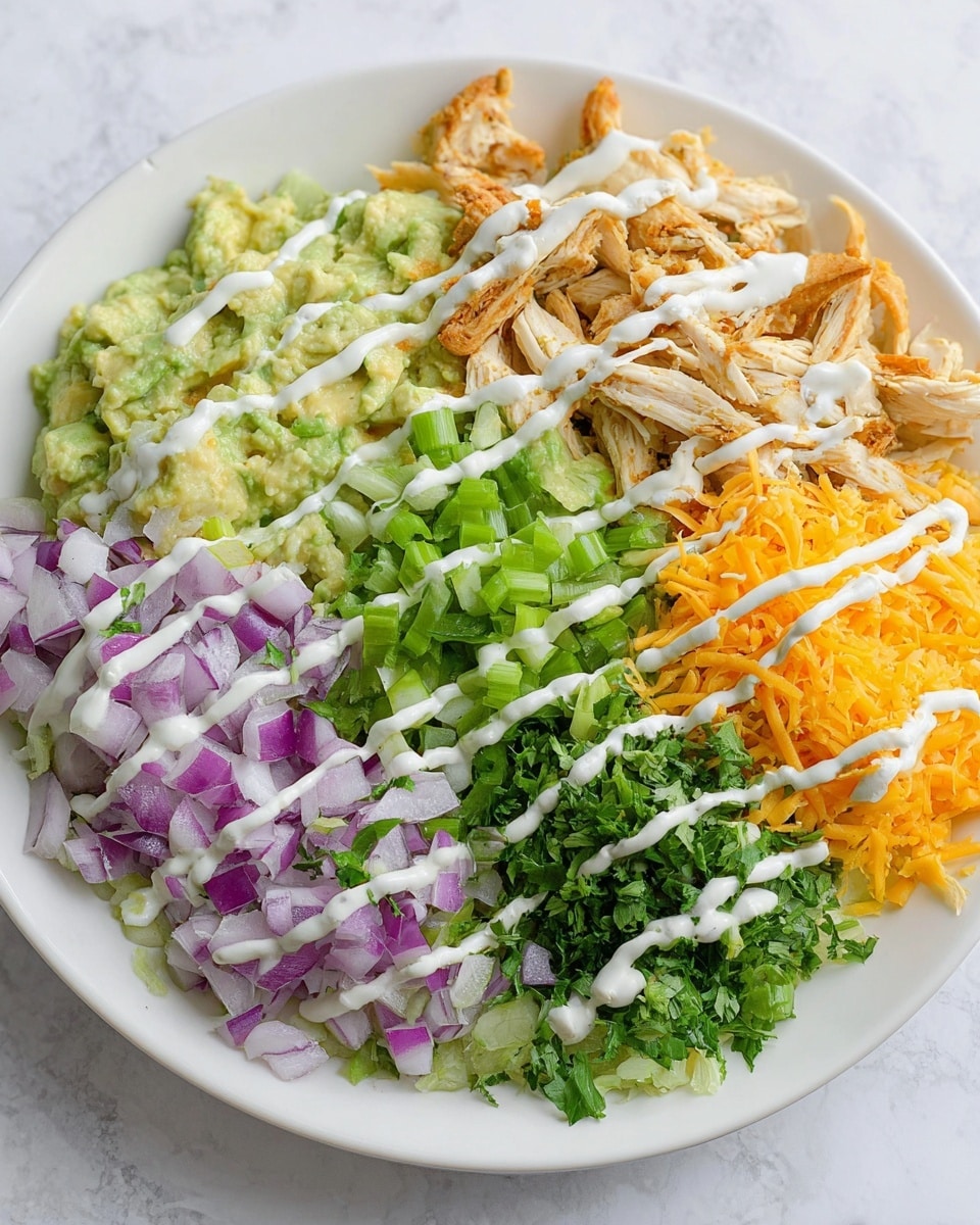 A white plate filled with five distinct layers arranged side by side. Starting from the left, there is a creamy light green layer with a slightly chunky texture, likely mashed avocado. Next to it is a finely chopped purple onion layer with small, crisp square pieces. In the center, fresh green parsley leaves and chopped green onions create a leafy texture. To the right of that is a layer of bright orange shredded cheese with a soft and slightly curly texture. The top layer, occupying the rightmost section, contains shredded light beige chicken with tender, fibrous strands. Thin white sauce lines are drizzled evenly across the entire dish in diagonal stripes. The plate sits on a white marbled surface. Photo taken with an iphone --ar 4:5 --v 7