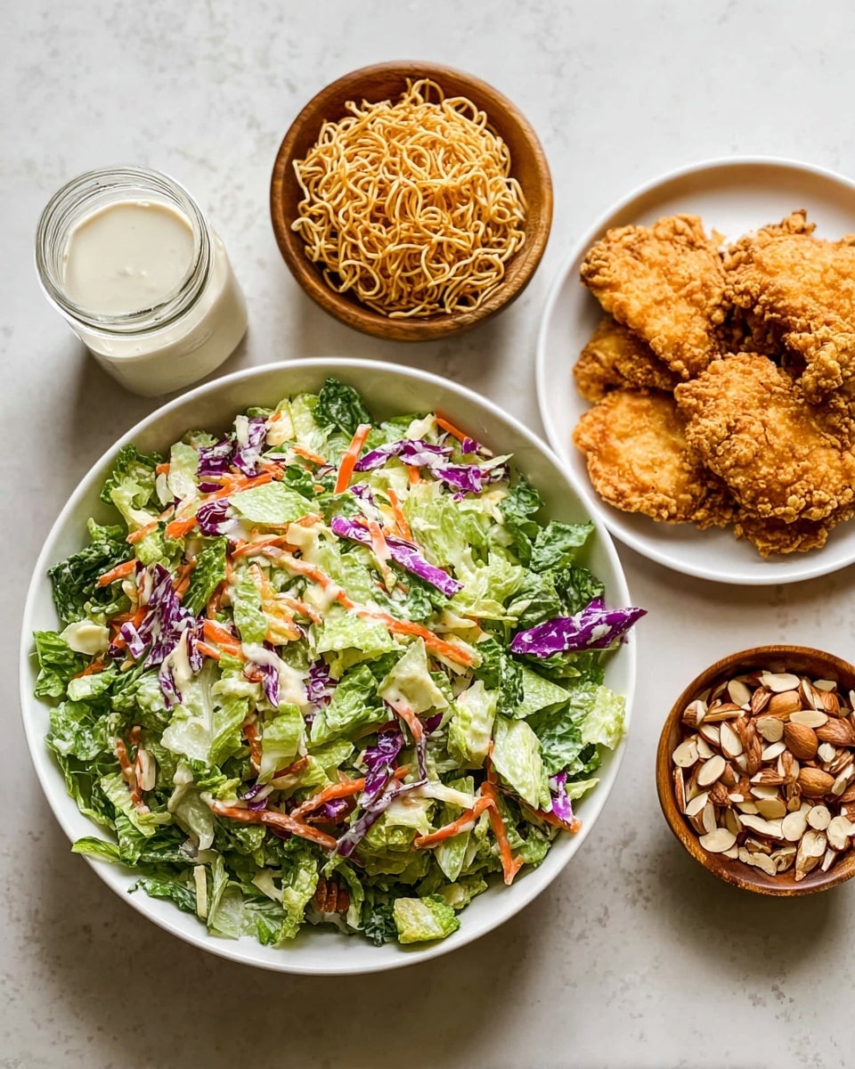 In the center is a large white plate with a fresh mixed salad made of several layers: light green lettuce leaves, thin purple cabbage shreds, and small orange carrot sticks scattered throughout, giving a colorful and crunchy look. To the right, on a white plate, there are four pieces of golden fried chicken arranged closely, showing a crispy and textured crust. Above the salad, there is a white bowl filled with light brown crispy noodles, and to the left, a small wooden bowl with a layer of mixed sliced almonds and nuts. Finally, on the far left, there is a glass jar with creamy white dressing. All items are placed on a white marbled surface. photo taken with an iphone --ar 4:5 --v 7