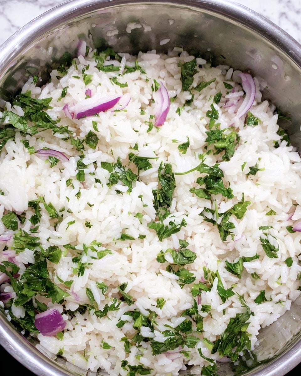 A close-up view of cooked white rice mixed with chopped fresh green parsley and small pieces of purple-red onion in a silver pot. The rice grains look soft and separate, with the green parsley leaves and onion bits scattered evenly throughout, creating a fresh and colorful mix. The background is a white marbled texture. photo taken with an iphone --ar 4:5 --v 7