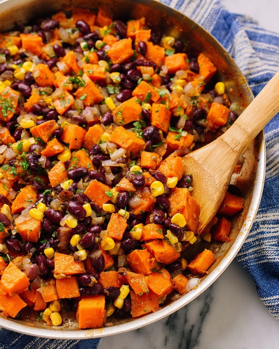 The image shows a close-up of a pan filled with a colorful mix of cooked vegetables. There are three main layers: the base layer is made of bright orange cubes of sweet potato, mixed with dark purple-black beans scattered evenly, and yellow corn kernels adding bright spots. The vegetables are mixed with finely chopped light beige onions and green herbs that add freshness. The texture looks soft yet distinct, with a wooden spatula resting in the pan stirring the mixture. The pan is set on a white marbled surface with a blue and white striped cloth nearby. Photo taken with an iphone --ar 4:5 --v 7