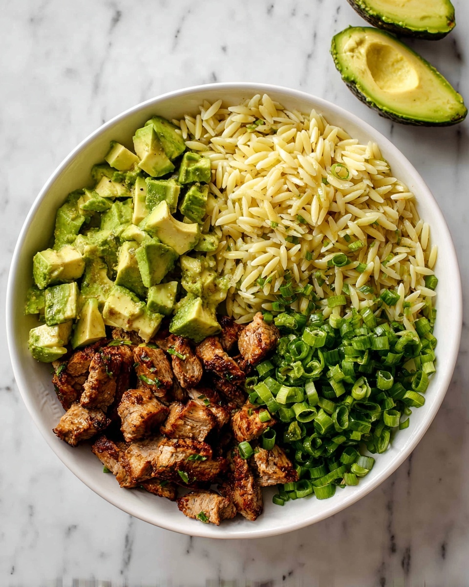 A white bowl holds a layered dish with four main parts arranged side by side: on the left, light green cubed avocado pieces with a smooth texture; next to it, pale yellow orzo pasta with a slight shine; on the bottom left, small chunks of browned grilled meat with a rough, cooked surface; and on the right, bright green chopped green onions with a fresh, crisp look. In the top right corner, two avocado halves are visible. The bowl sits on a white marbled surface. Photo taken with an iphone --ar 4:5 --v 7