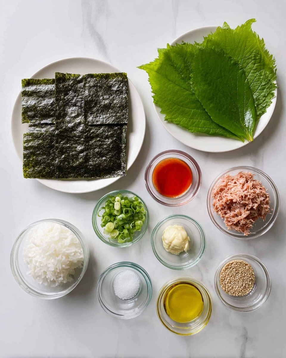 The image shows ingredients neatly arranged on a white marbled surface. On the left side, a white plate holds a stack of nine dark green seaweed sheets, and above it, another white plate has several large, shiny green leaves placed in a small pile. To the right, there are several small clear glass bowls each holding different ingredients: a bowl with white cooked rice, a bowl with flaked tuna, a small bowl with bright red sauce, another with golden oil, one with creamy mayonnaise, a bowl of chopped green spring onions, a bowl with white salt, and lastly a bowl containing tan-colored sesame seeds. Each ingredient is clearly separated and easy to see. Photo taken with an iphone --ar 4:5 --v 7