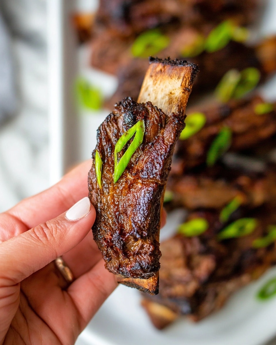 The image shows several pieces of grilled beef short ribs stacked closely together on a white plate, each piece rich brown with dark char marks and visible bone sections. The meat has a textured surface with a shiny glaze, giving it a juicy look. Small, thin slices of bright green onions are sprinkled evenly over the ribs, adding a fresh contrast to the deep brown colors. The background is a white marbled texture that highlights the warm tones of the dish. photo taken with an iphone --ar 4:5 --v 7