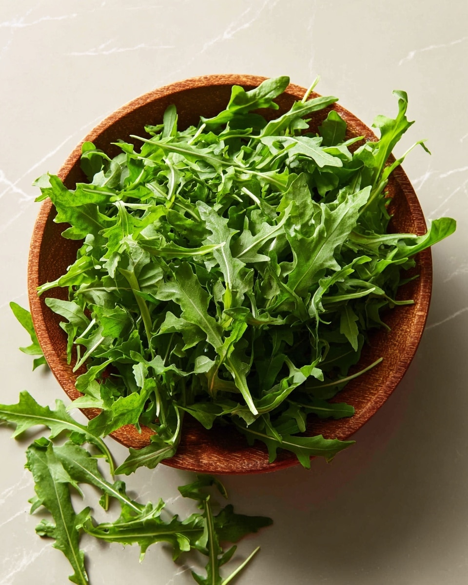 A wooden bowl filled with fresh, bright green arugula leaves. The arugula is loose and fluffy, with some leaves spilling out of the bowl onto the white marbled surface beneath. The leaves have a slightly jagged texture and look crisp and fresh. Soft light from the side casts gentle shadows, highlighting the different shades of green and the natural shapes of the leaves. Photo taken with an iphone --ar 4:5 --v 7