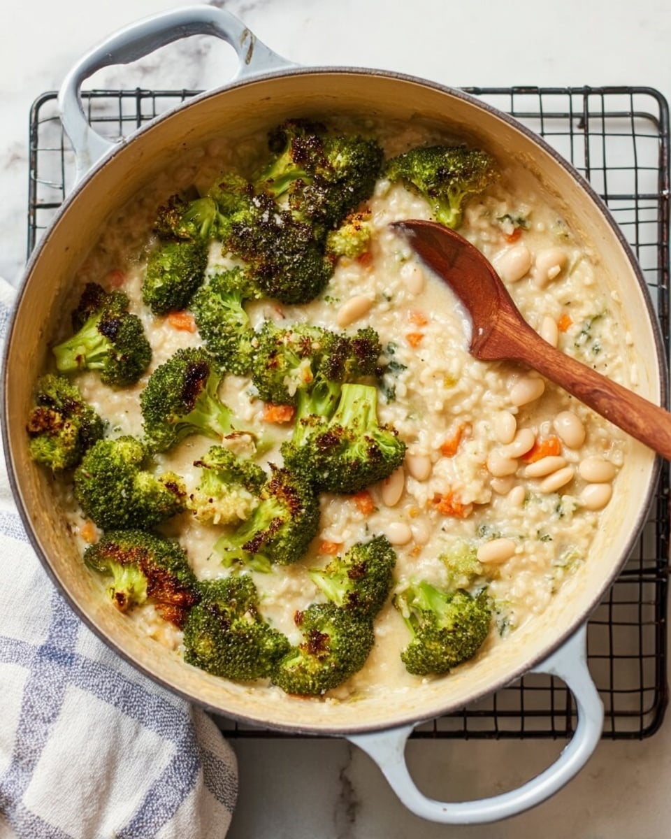 A large round pot with two handles holds a creamy mixture with three clear layers: bright green broccoli florets with some dark brown roasted spots sit mostly on the left side; a thick, light beige risotto with small orange carrot pieces fills the center and right side; pale white beans cluster mainly on the bottom right edge. A wooden spoon rests inside the pot, its bowl partially submerged in the risotto near the beans. The pot sits on a black wire rack over a white marbled surface with a folded white and blue kitchen towel nearby. photo taken with an iphone --ar 4:5 --v 7