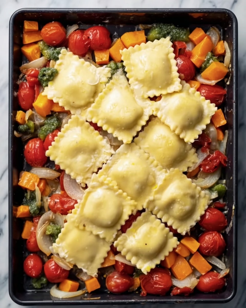 The image shows a black baking tray filled with cooked vegetables and uncooked ravioli. The base layer consists of colorful roasted vegetables including red cherry tomatoes, green and orange bell pepper pieces, and light caramelized onion slices scattered evenly across the tray. On top of this vegetable layer, there is one layer of uncooked ravioli placed in a group. The ravioli are square-shaped with a light yellow color and crimped edges, showing a soft texture. The overall look is vibrant with contrasting colors from the vegetables and the pale yellow ravioli. The tray is placed on a white marbled textured surface photo taken with an iphone --ar 4:5 --v 7