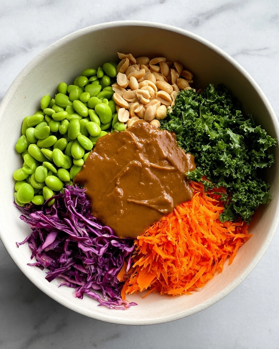 A white bowl holds seven distinct layers of colorful ingredients arranged side by side. Starting from the bottom left, there is a large pile of bright green edamame beans with a smooth texture. Above it, a small cluster of light beige peanuts is nestled next to dark green kale leaves with curly edges. Moving clockwise, finely chopped dark green parsley sits beside light green sliced scallions. Next, shredded vibrant purple cabbage forms a textured layer. In the bottom right, finely grated bright orange carrots fill the space. The center of the bowl is covered with a thick, smooth brown sauce, partially covering some of the adjacent layers. The bowl is set on a white marbled surface. Photo taken with an iphone --ar 4:5 --v 7