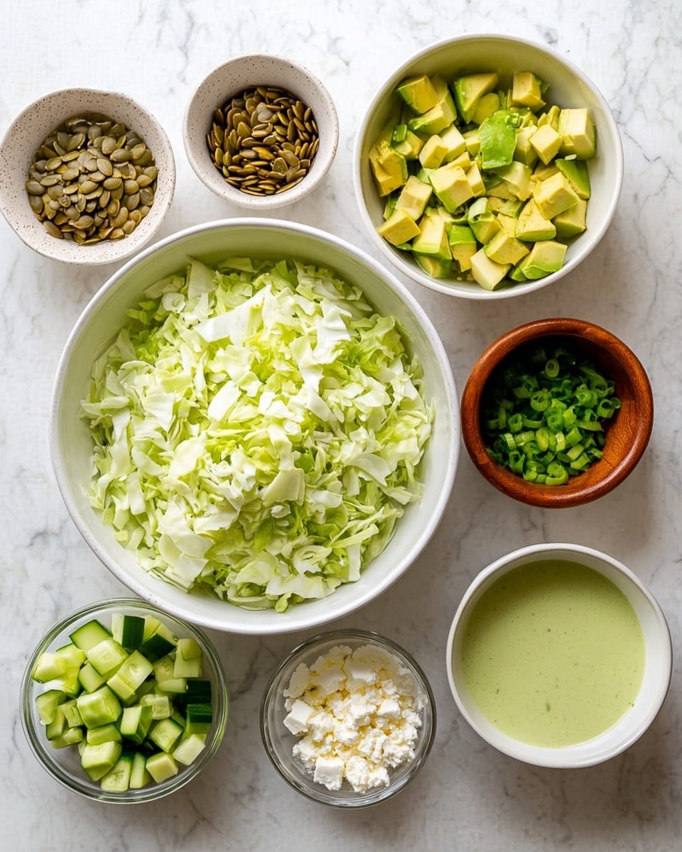 Several white bowls are placed on a white marbled surface, each holding a different ingredient. The largest white bowl in the center is filled with chopped light green cabbage. To the left, a large white bowl contains small light and dark green chopped cucumber pieces. Above it, a smaller clear bowl holds brown pumpkin seeds. To the right, a smaller white bowl is full of diced yellow-green avocado. Next to it, a small brown bowl has chopped bright green scallions. Below, a small clear bowl holds crumbly white cheese. Finally, a clear small bowl contains a smooth, light green dressing. All items are separated and arranged neatly. Photo taken with an iphone --ar 4:5 --v 7