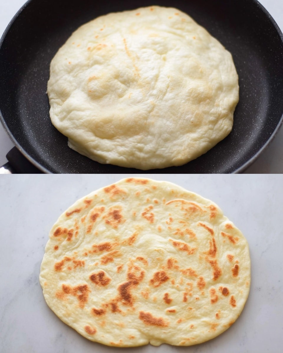 A close-up view of two soft, folded flatbreads stacked on a pale wooden surface. The flatbread on top is held gently by a woman's hand and has a slightly puffy texture with golden brown spots from cooking. It is sprinkled with small pieces of green herbs and light reddish spices, which add contrast to the warm beige color of the bread. The edges are soft and slightly uneven, showing the tender, fluffy inside. The second flatbread is partly visible beneath the top one, matching in color and texture. Photo taken with an iphone --ar 4:5 --v 7