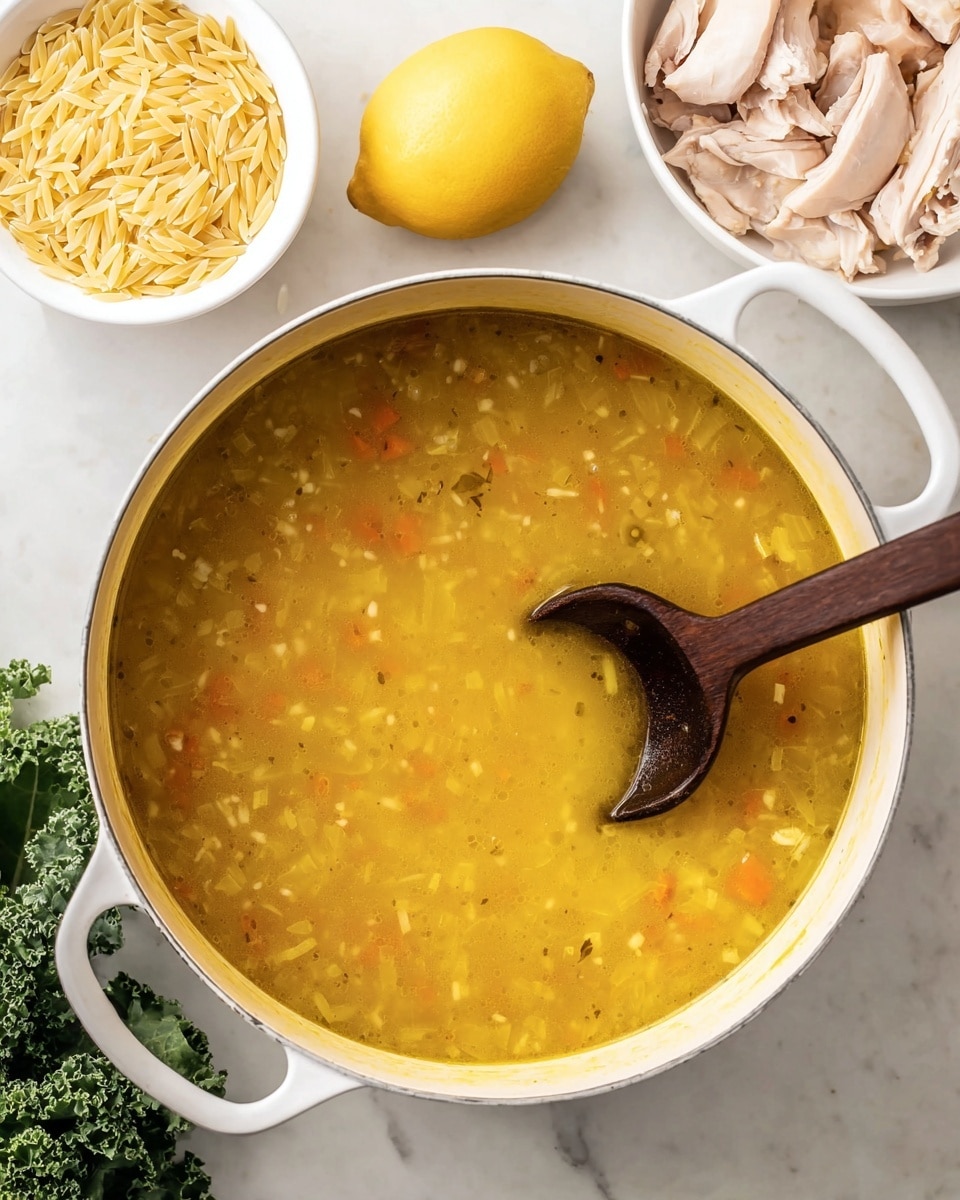 A white pot filled with golden yellow soup textured with small bits of vegetables and onions, a dark wooden spoon resting inside the pot, a small white bowl with dry light yellow orzo pasta to the upper left, a whole bright yellow lemon in the middle back, and another white bowl with pale pink cooked chicken pieces to the upper right, all placed on a white marbled surface, with some fresh green kale partially visible on the lower left side, photo taken with an iphone --ar 4:5 --v 7