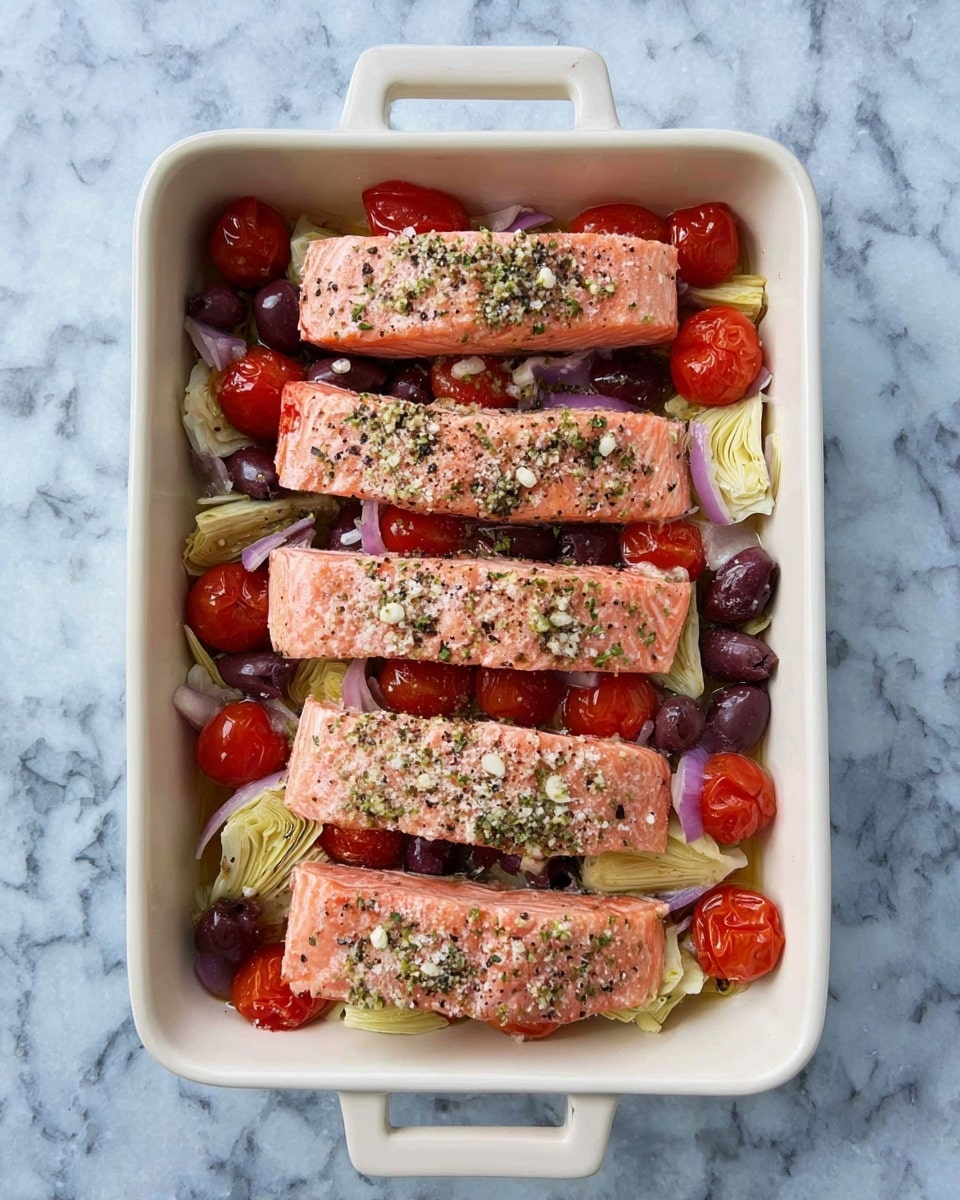 The image shows a white rectangular casserole dish with two handles, placed on a white marbled surface. Inside, there are four evenly spaced pieces of pink salmon fillets on top. Beneath the salmon, there is a mix of halved red cherry tomatoes, purple olives, and sliced pale green artichoke hearts, layered with some finely chopped purple onions. The salmon pieces are sprinkled with coarse white salt, black pepper, and green herbs, giving a fresh and seasoned look. The colors are vibrant and fresh, with a balanced arrangement of ingredients. photo taken with an iphone --ar 4:5 --v 7