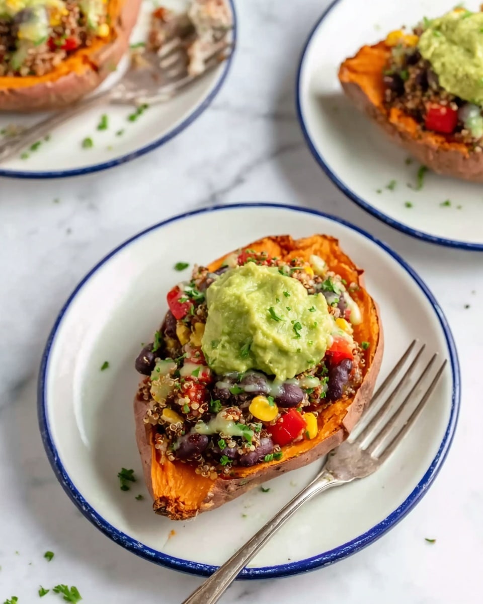 The image shows a roasted sweet potato half placed on a white plate with a blue rim, resting on a white marbled surface. The sweet potato is filled with three visible layers: a base of soft, orange sweet potato flesh; a middle layer made of a mix of quinoa, black beans, diced red bell peppers, and corn, creating a colorful, textured topping; and a top layer of bright green guacamole scoop, slightly chunky, placed on one side. There is also a light drizzle of a creamy sauce over the filling, and some chopped green herbs sprinkled on top. A silver fork lies on the plate angled toward the potato. Another similar plate appears partly in the top left corner with a fork near it, and a third sweet potato half is visible in the top right corner. Photo taken with an iphone --ar 4:5 --v 7