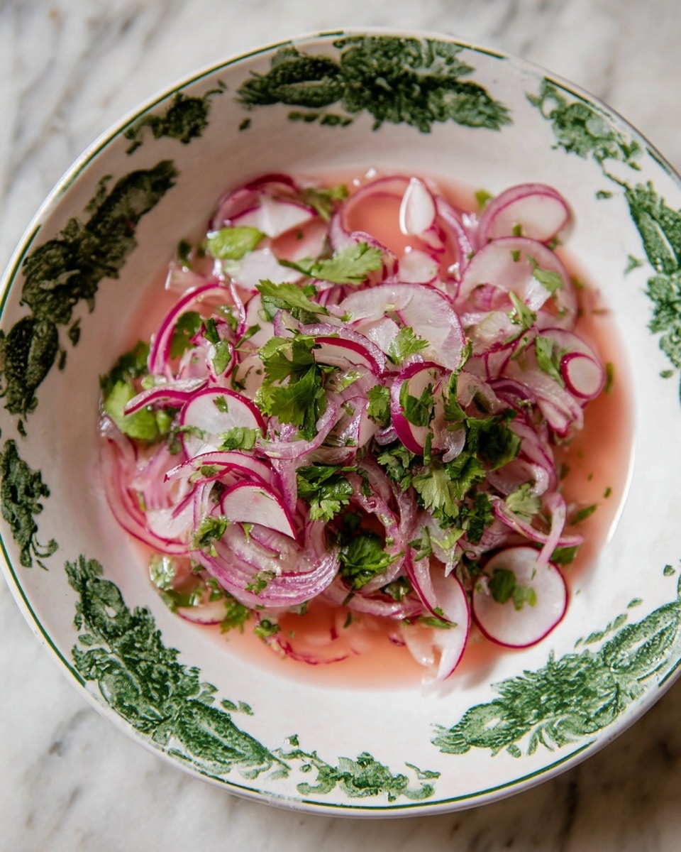 The dish is a salad served in a white bowl with green floral patterns around the rim. It has thin slices of red onion that are light purple and some thinly sliced radishes with white centers and red edges. Bright green cilantro leaves are scattered on top and mixed in evenly. The salad sits in a light pink liquid that partially covers the bottom of the bowl. The bowl is placed on a white marbled surface. photo taken with an iphone --ar 4:5 --v 7