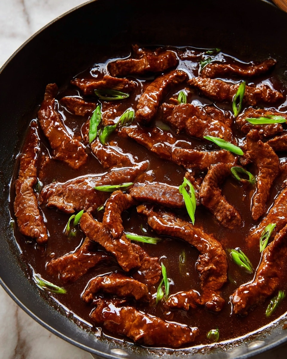 The image shows a black pan filled with many strips of cooked meat in a thick dark brown sauce. The meat strips have a shiny texture from the sauce and are uneven but tender looking. There are small pieces of sliced green onion sprinkled on top, adding a touch of bright green color. The sauce is glossy and rich, covering all the meat evenly. The pan is placed on a white marbled surface. photo taken with an iphone --ar 4:5 --v 7