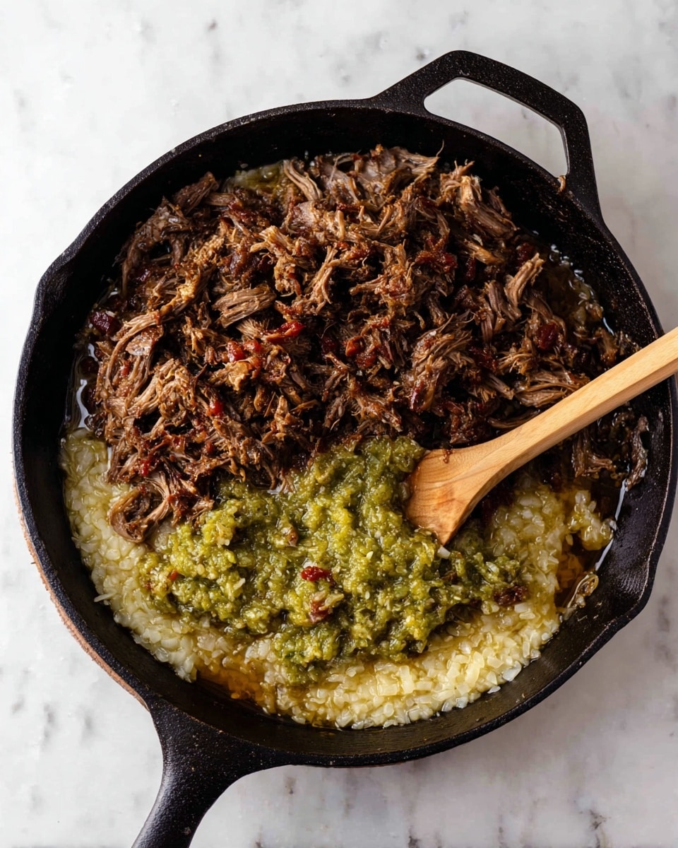 A black cast iron skillet holds a layered mixture of cooked ingredients on a white marbled texture. At the bottom, there is a soft, pale layer of cooked onions spreading across the pan. Above that, a chunky green sauce sits on part of the onions, showing a textured mixture of small, light green pieces. The top layer consists of shredded, dark brown cooked meat, scattered unevenly with some red bits mixed in. A light brown wooden spoon rests inside the skillet, touching the green sauce and some shredded meat, leaning against the side. Photo taken with an iphone --ar 4:5 --v 7