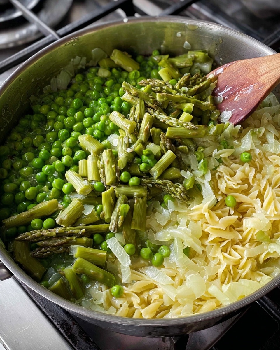 A close-up image of a metal pan on a stove filled with a mix of cooking ingredients. The bottom layer consists of soft, light yellow chopped onions. On top, there is a layer of pale yellow small pasta pieces mixed with the onions. The upper layer features bright green chopped asparagus pieces scattered unevenly, with small frosted green peas concentrated on the left side. A wooden spoon is stirring the ingredients on the right side of the pan. The scene has natural light showing the fresh and steaming texture of the vegetables and pasta. Photo taken with an iphone --ar 4:5 --v 7