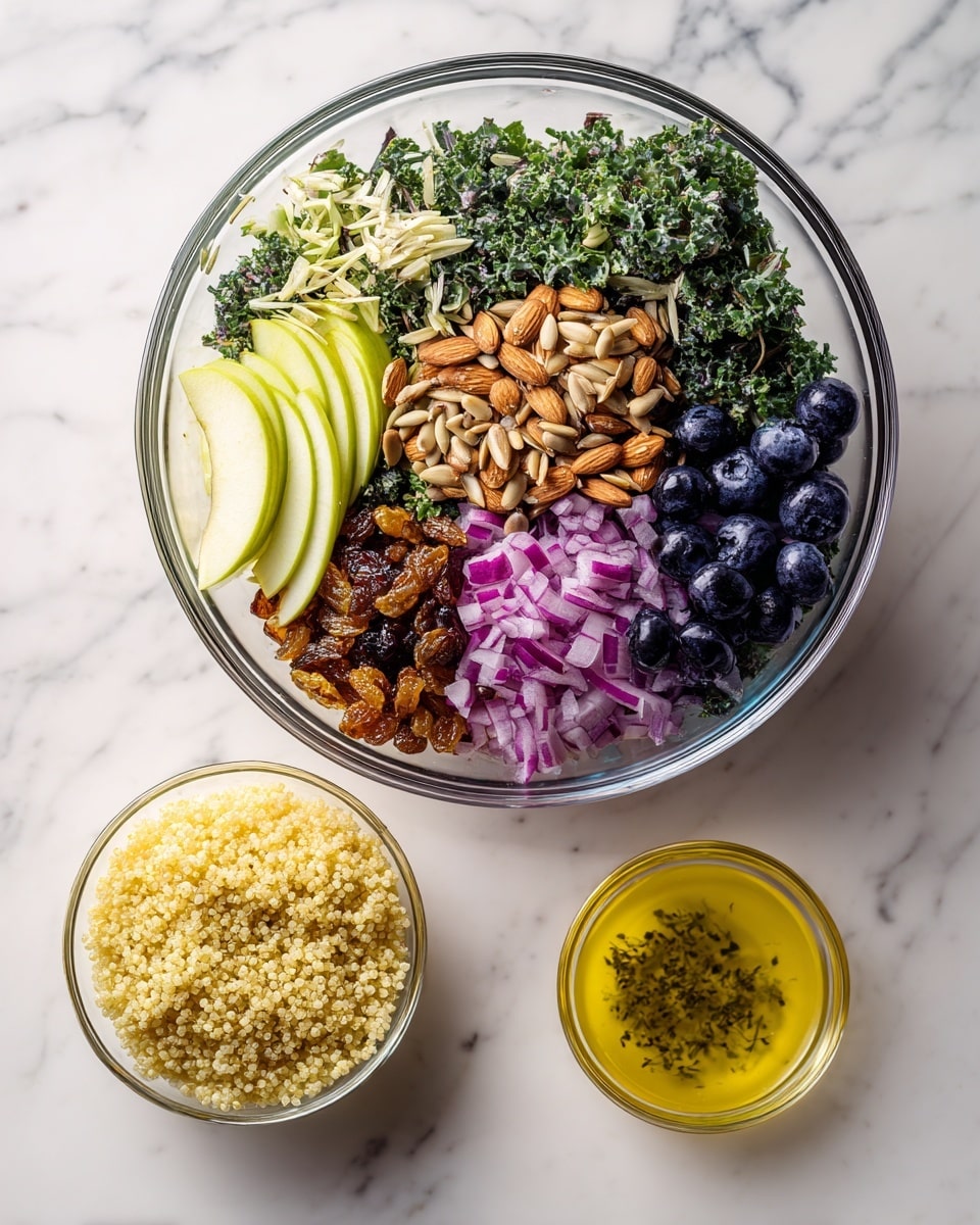 A clear glass bowl sits on a white marbled surface, filled with six distinct layers of fresh ingredients arranged side by side. Starting from the left, there are thin pale green slices of apple, next to leafy dark green kale and lighter shredded cabbage. Toward the center, a pile of small tan sunflower seeds is placed next to golden brown raisins, and overlapping with thin slices of light brown almonds. On the right side, there are small chopped pieces of purple-red onion, with a cluster of plump deep blue blueberries beside them. Next to the bowl, on the white marbled surface, there is a smaller clear bowl filled with pale yellow cooked quinoa, and below the main bowl, a small clear cup holds a golden yellow dressing with small green herb pieces visible. photo taken with an iphone --ar 4:5 --v 7