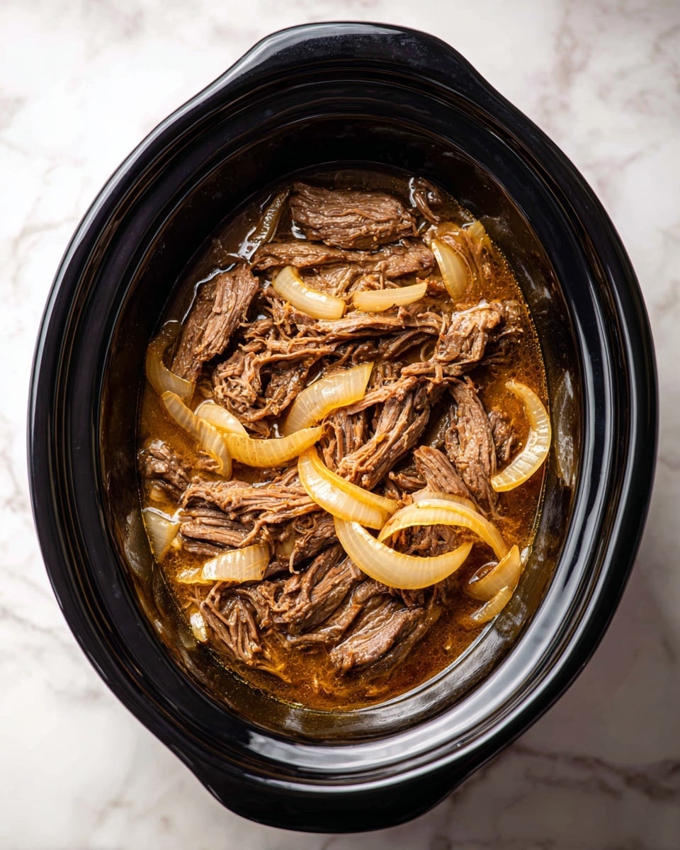 The image shows a black slow cooker filled with shredded cooked beef mixed with cooked onion slices, all sitting in a light brown broth. The beef pieces are dark brown and fibrous, layered unevenly throughout the slow cooker, while the onion slices are translucent and light orange, scattered on top and mixed in with the beef. The slow cooker is placed on a white marbled surface. photo taken with an iphone --ar 4:5 --v 7