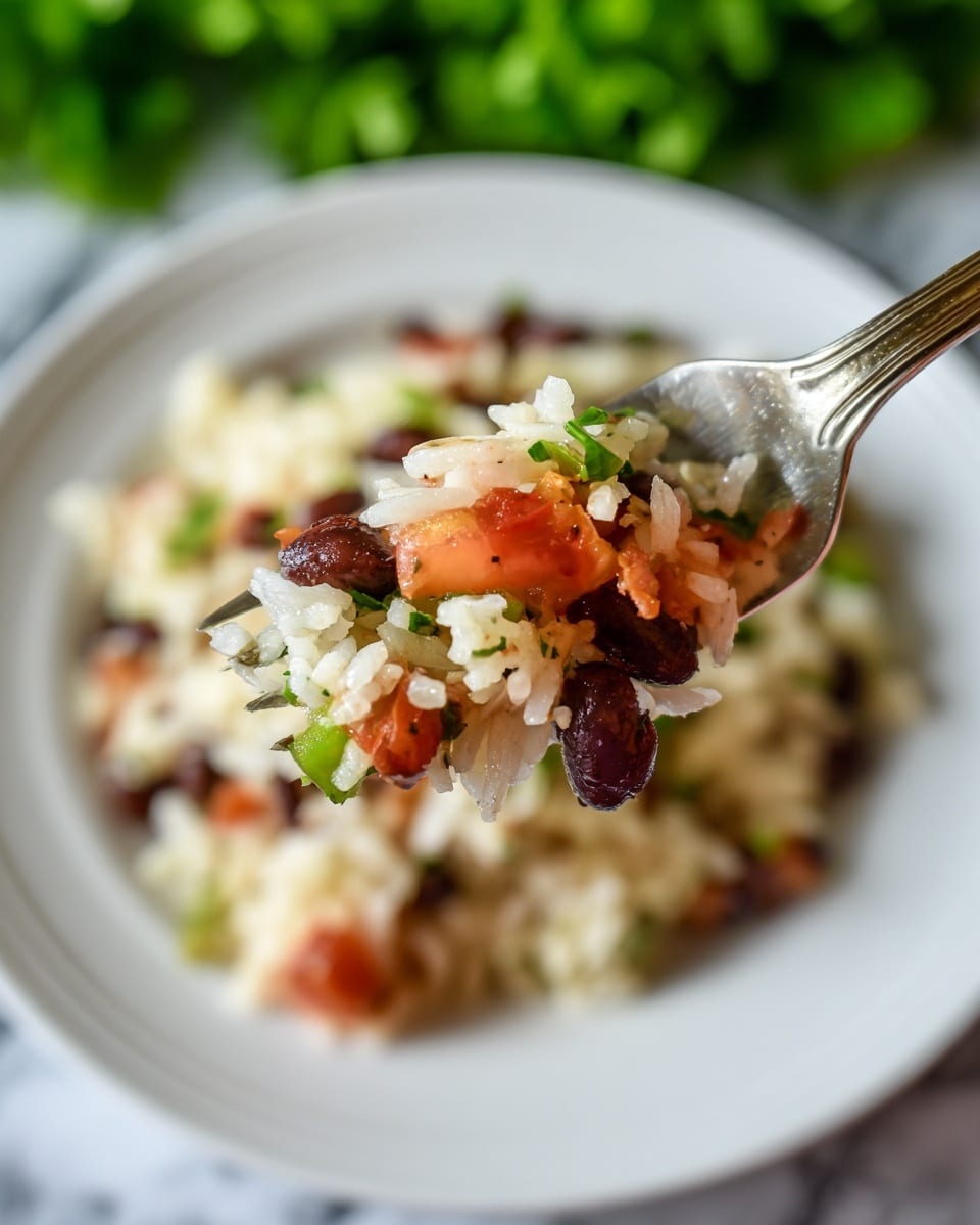 A close-up image shows a fork holding a mix of white rice, small black beans, diced green peppers, and bits of red tomatoes, with the same mixture filling a white plate below. The rice is soft and moist, the black beans are round and shiny, the green peppers are small, cubed, and slightly translucent, and the tomatoes add a splash of red color. The background features a bright green leafy texture, with a white marbled surface below. The focus is sharp on the forkful of food, with the plate and background slightly blurred. photo taken with an iphone --ar 4:5 --v 7