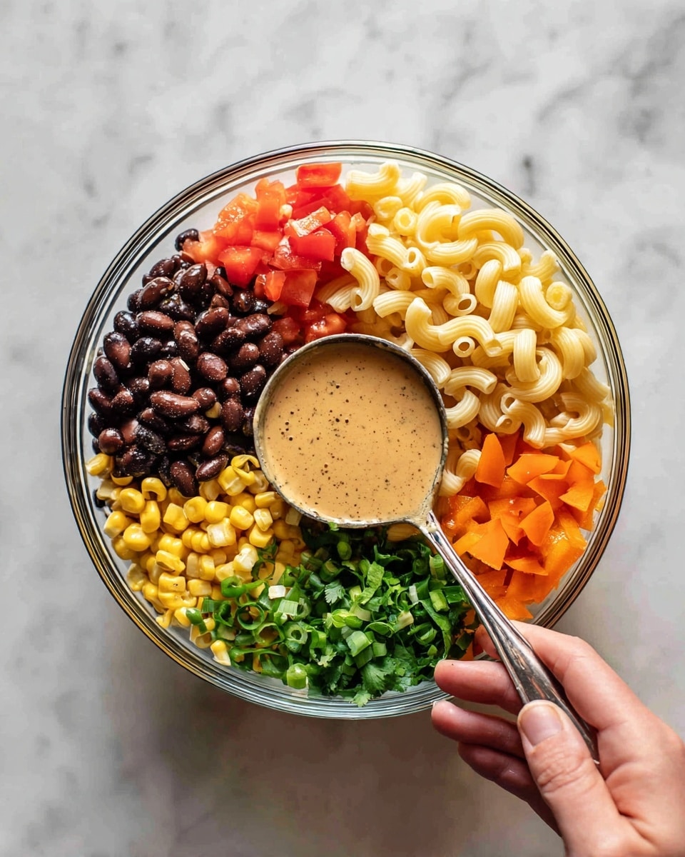 The image shows a clear glass bowl on a white marbled surface with seven different ingredients placed around a creamy sauce in the center. The ingredients are arranged in layers: black beans (dark brown and shiny) at the top left, pale yellow elbow macaroni at the top right, finely chopped red tomatoes on the left, yellow corn kernels below the tomatoes, green chopped scallions next to the corn, bright orange chopped bell peppers next to the scallions, and green cilantro leaves to the right of the peppers. A silver spoon covered in the light brown creamy sauce rests on top of the sauce in the center of the bowl, with a woman's hand holding it. Photo taken with an iphone --ar 4:5 --v 7