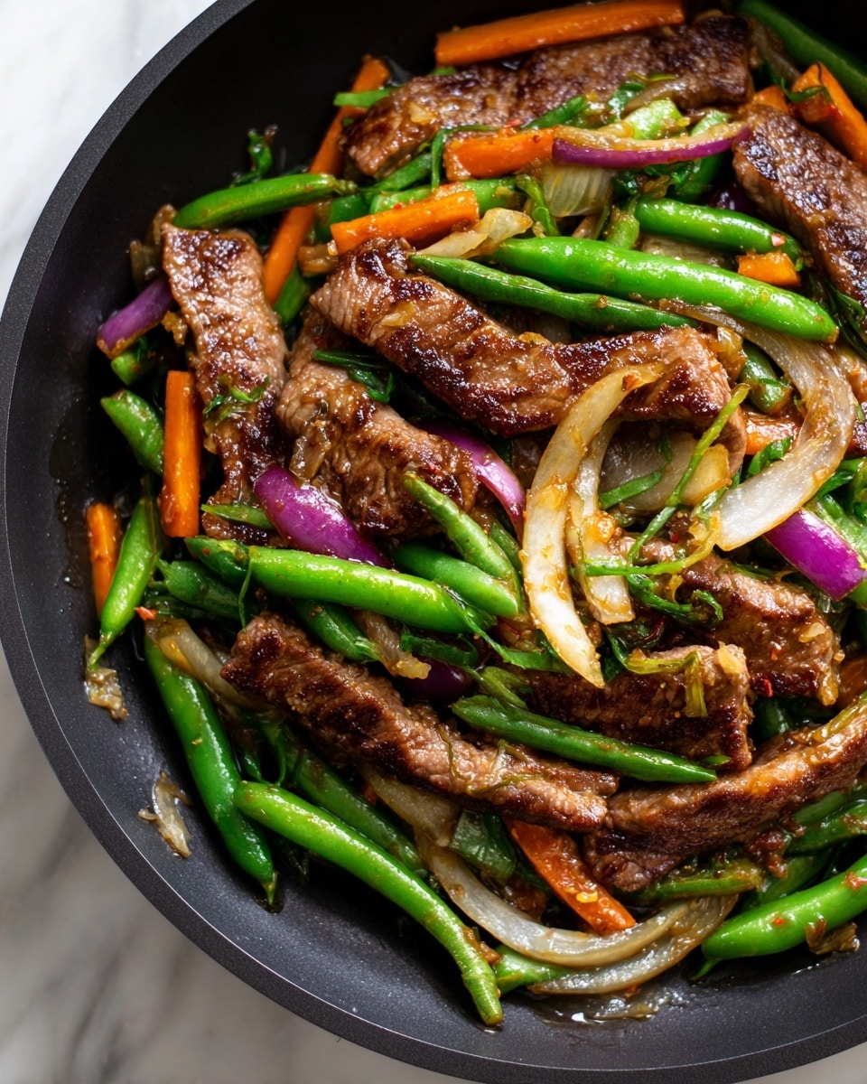 This is a close-up view of a stir-fry dish cooked in a black pan. The top layer has brown, grilled strips of beef with a slightly charred texture. Underneath and mixed around the beef, there are bright green snap peas, orange carrot strips, and thin, translucent slices of light purple onions. The vegetables look fresh and shiny with a sauce that has a light brown color and a glossy texture, coating all the ingredients evenly. There is steam rising from the pan. The surface beneath the pan is a white marbled texture. photo taken with an iphone --ar 4:5 --v 7