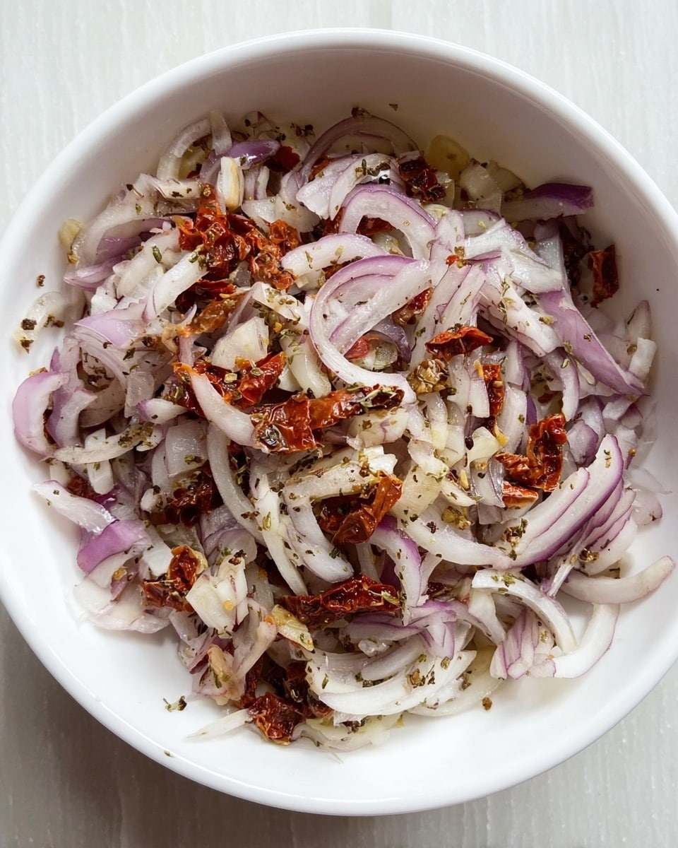 A white bowl sits on a white marbled surface, filled with a mix of thinly sliced pale purple onions, small crushed white garlic pieces, and chopped sun-dried tomatoes in reddish-brown hues. The ingredients are finely chopped and evenly mixed, showing the layers of onion strips intertwined with bits of garlic and sun-dried tomato, sprinkled lightly with dried herbs and black pepper. The texture varies from the crisp softness of onions to the chewy pieces of sun-dried tomatoes, all contained within the smooth white bowl. photo taken with an iphone --ar 4:5 --v 7