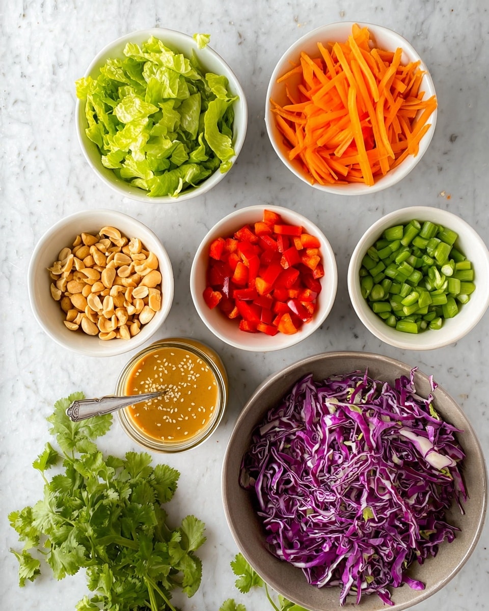 The image shows seven small white bowls arranged in a circle on a white marbled surface, each bowl filled with different fresh ingredients. Starting from the top left and moving clockwise, the first bowl contains bright green chopped lettuce, the second bowl has thin orange carrot sticks, the third bowl holds chopped green beans, the fourth bowl is filled with mixed chopped nuts including peanuts and almonds, the fifth bowl has chopped green onions, the sixth bowl contains diced red bell peppers, and the large bowl in the center is filled with purple shredded cabbage. In the middle below the bowls, there is a glass jar with a light brown sesame seed dressing and a spoon inside it. Some fresh cilantro leaves are placed on the surface near the bottom left corner. The photo taken with an iphone --ar 4:5 --v 7