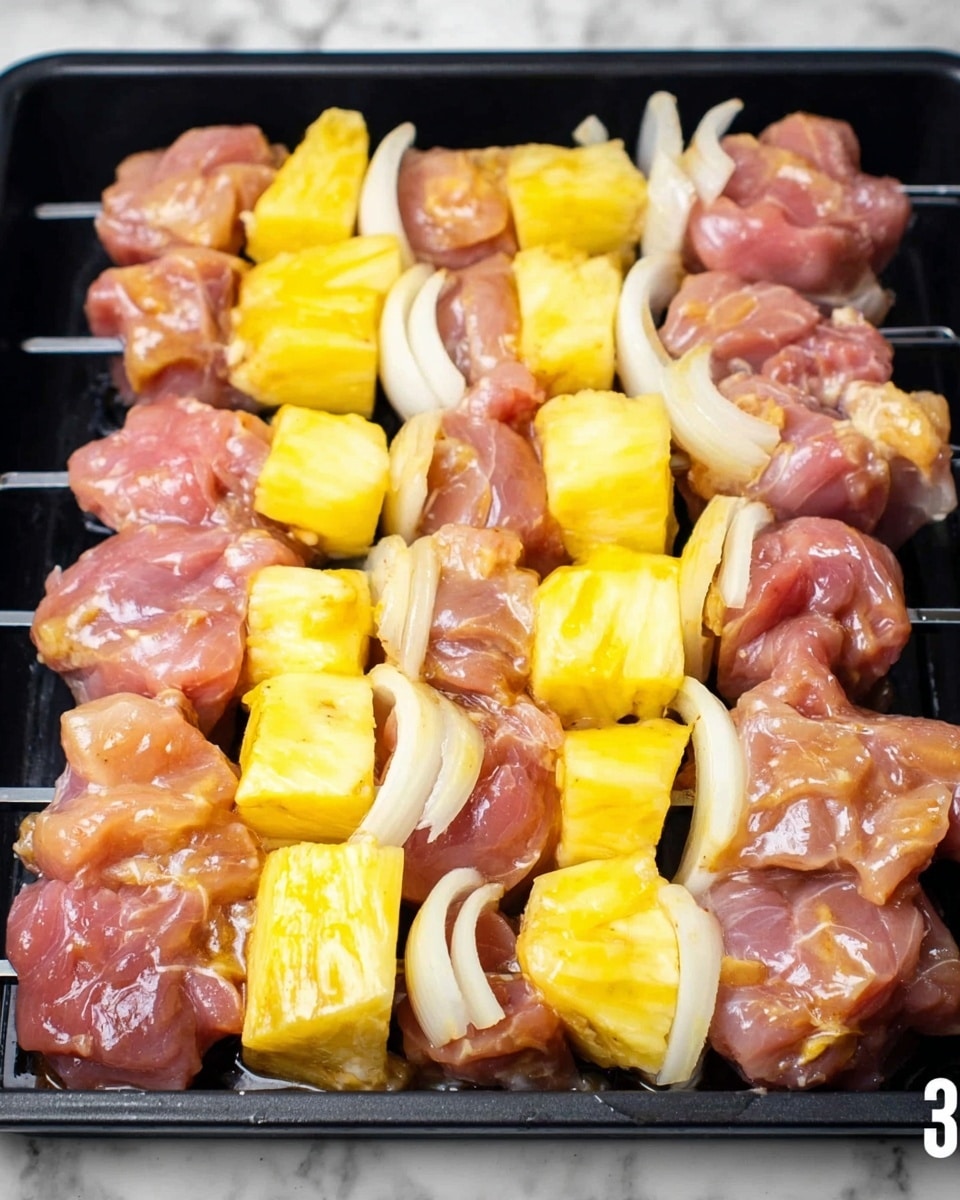 The image shows a black grilling tray filled with several skewers of uncooked food. Each skewer has three main layers that repeat: pale pink pieces of raw meat, bright yellow chunks of pineapple with a juicy texture, and thin white slices of onion that curve around the meat. The meat pieces are irregular in shape with a glossy, wet surface from marinade or natural moisture. The pineapple pieces are thick and vibrant, contrasting with the softer color of the meat, and the onion slices are slightly translucent. There is some light reflection on the wet food and on the black tray, indicating moisture. The background is a white marbled texture. photo taken with an iphone --ar 4:5 --v 7