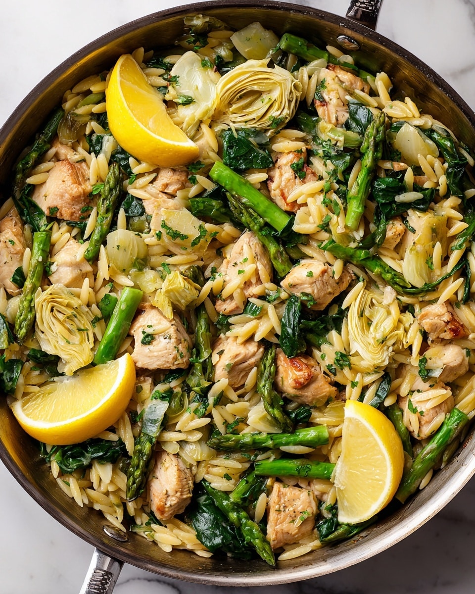 This dish in a pan shows a mix of small yellow orzo pasta pieces, light brown cooked chicken chunks, and bright green vegetables like asparagus and spinach. There are also pale yellow artichoke hearts scattered throughout. Two wedges of fresh bright yellow lemon sit on top, adding a splash of color. The pan is full, with the ingredients looking fresh and mixed well together, all on a white marbled surface photo taken with an iphone --ar 4:5 --v 7