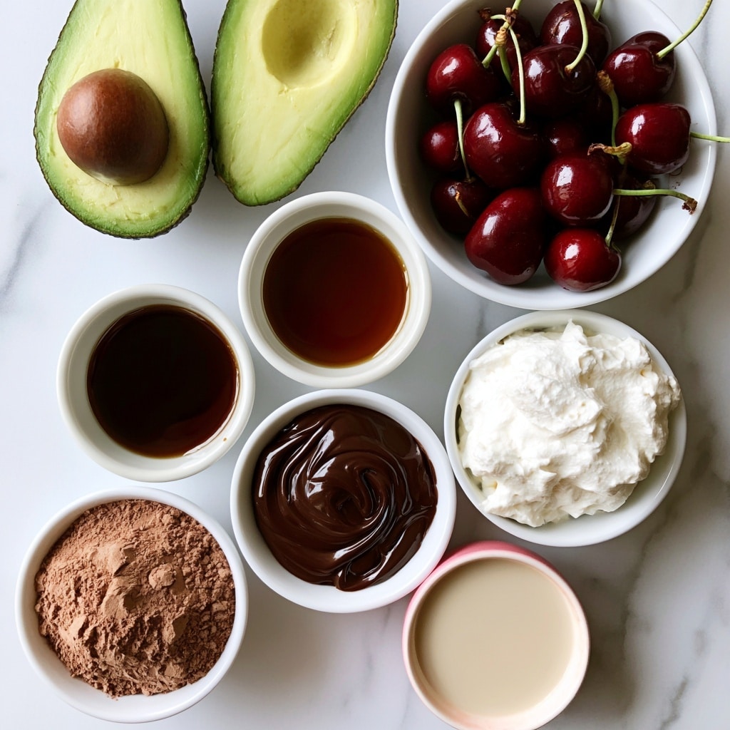 The image shows seven white bowls and one half avocado arranged on a white marbled surface. At the top left, two halves of a green avocado with a smooth texture and one large brown pit sit side by side. To the right, a white bowl filled with shiny dark red cherries with green stems stands out. Below the avocado and cherries, a small white bowl contains dark brown maple syrup with a glossy surface. Below that, a white bowl filled with light brown cocoa powder with a velvety texture is placed next to a white bowl of melted dark chocolate, rich and shiny with smooth swirls. To the right of the cocoa powder, there is a white bowl filled with creamy white dairy-free whipping cream with a slightly lumpy texture. Below the cream, a small white bowl with a pink edge holds light beige dairy-free milk with a smooth surface. Photo taken with an iphone --ar 4:5 --v 7