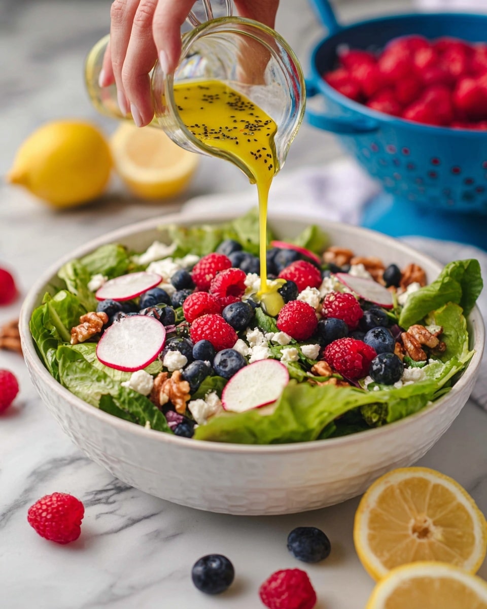 A white bowl filled with a fresh salad showing five layers: the base layer is bright green lettuce leaves, the second layer has thin slices of pink and white radish, the third layer has scattered whole red raspberries and dark blue blueberries, the fourth layer consists of small white cheese pieces, and the top layer has light brown walnut pieces. A woman's hand is pouring yellow dressing with black seeds from a clear glass container over the salad. Around the bowl, there are lemon halves, more raspberries and blueberries on a white marbled surface, and a blue colander with raspberries in the background. photo taken with an iphone --ar 4:5 --v 7
