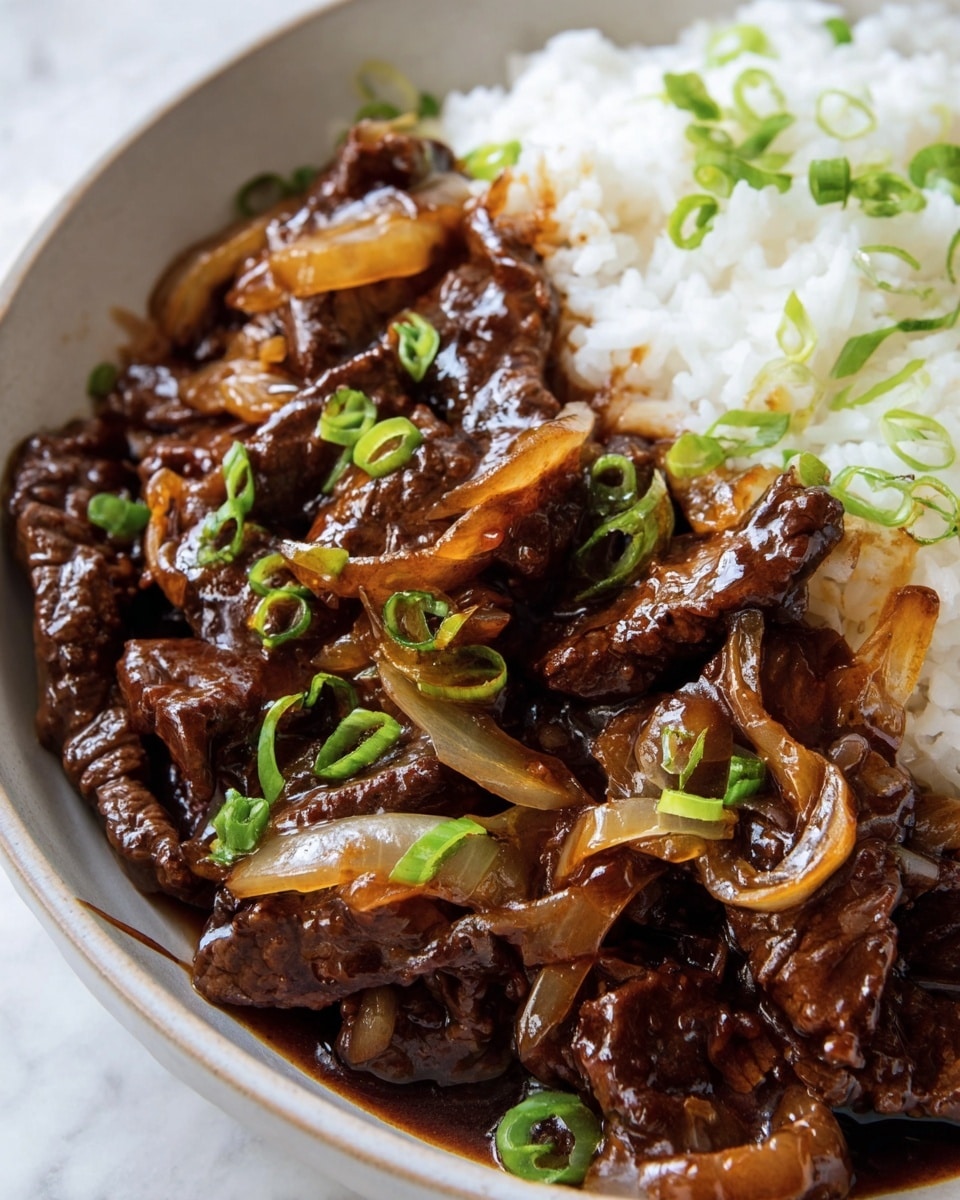 A close-up view of a white bowl filled about half with cooked dark brown beef strips and caramelized onion slices mixed with a rich, shiny brown sauce, topped with bright green chopped scallions scattered over the dish. On one side of the bowl, there is a serving of white fluffy rice with a few pieces of scallions on top. The bowl sits on a white marbled surface. photo taken with an iphone --ar 4:5 --v 7