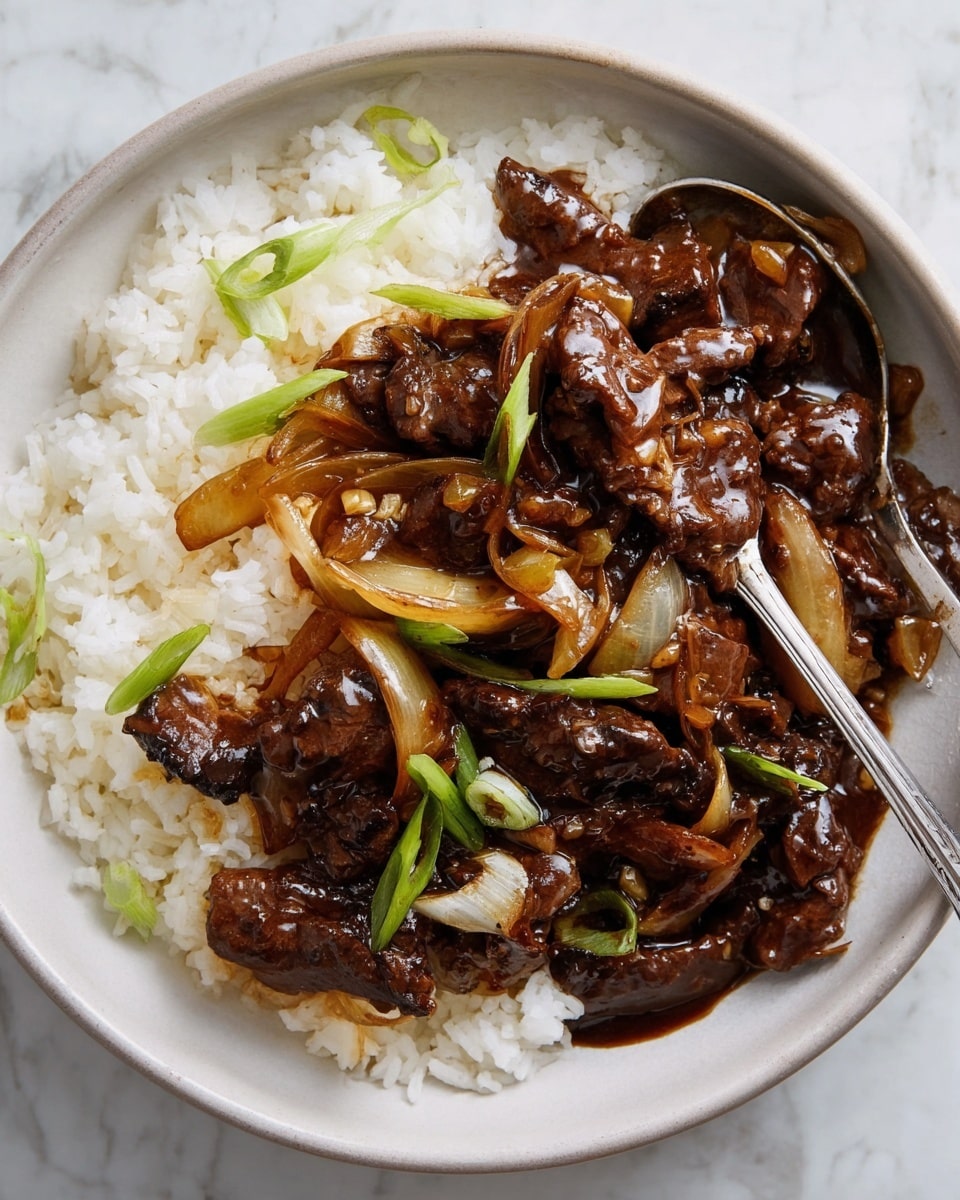 The dish shows a white shallow bowl filled with two main layers. The bottom layer is white steamed rice with a fluffy texture and some green slices of spring onions sprinkled on top. The top layer is a dark brown glossy beef stir-fry mixed with thick slices of translucent cooked onions, creating a rich, shiny coating. A silver fork rests partially in the food, mixing the beef and onion sauce with rice. The bowl is placed on a white marbled texture surface. Photo taken with an iphone --ar 4:5 --v 7