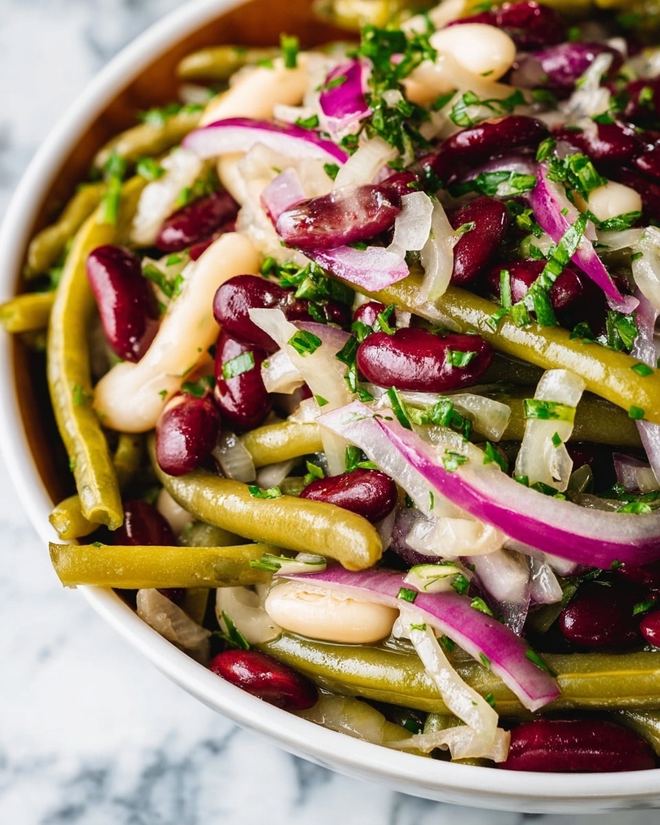 A round wooden bowl filled with a colorful salad sits on a white marbled surface. The salad has three main layers: the bottom layer is green beans cut into small pieces, the middle layer is white and dark red kidney beans, and the top layer has thinly sliced white and purple onions mixed with chopped green herbs. A silver fork rests inside the bowl on the right side, and a white cloth with a red stitch detail lies beside the bowl. A bunch of green parsley is seen in the top right corner, adding more color. photo taken with an iphone --ar 4:5 --v 7